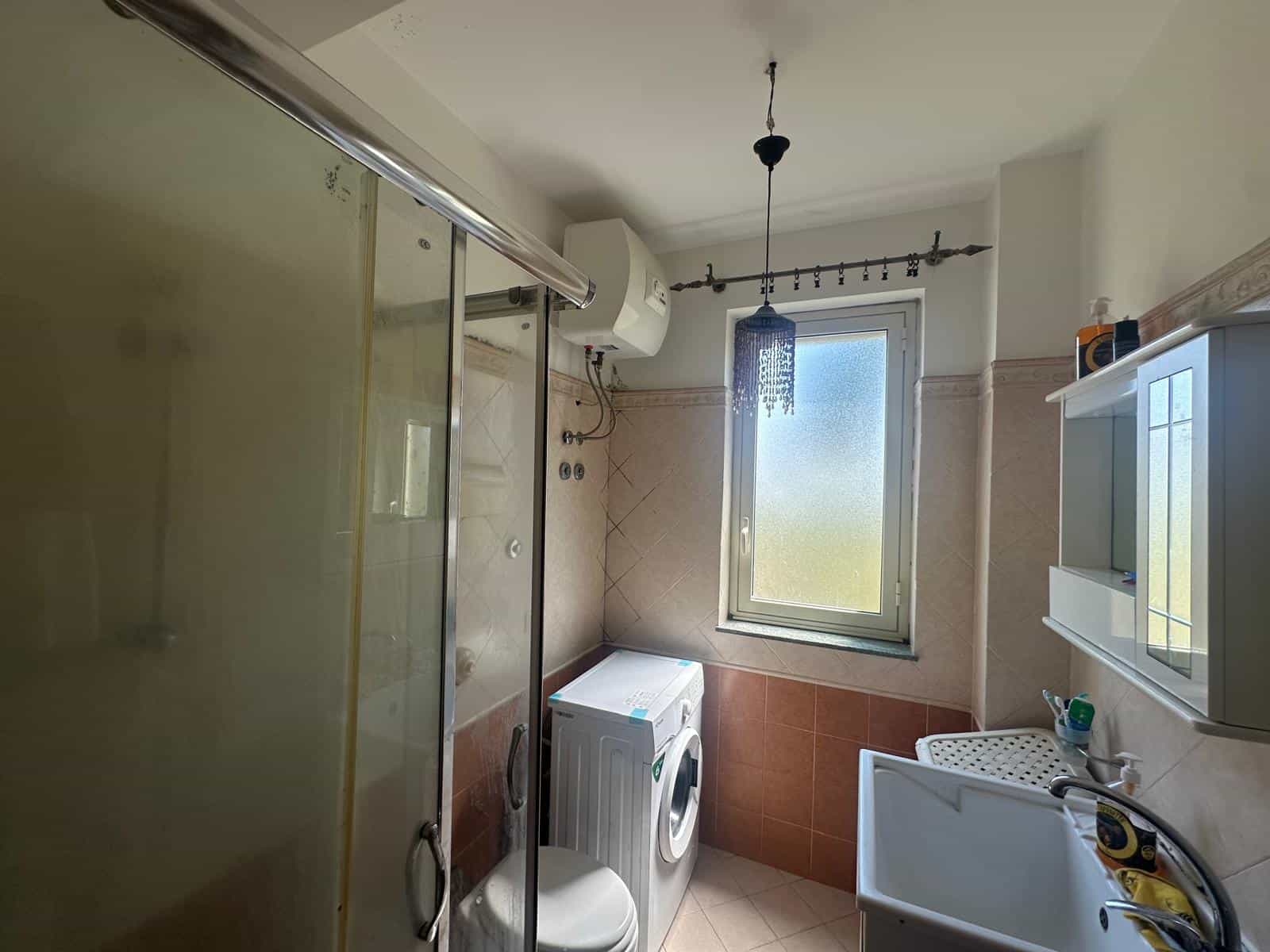 Bagno con lavatrice, finestra e doccia in un appartamento a Milazzo.