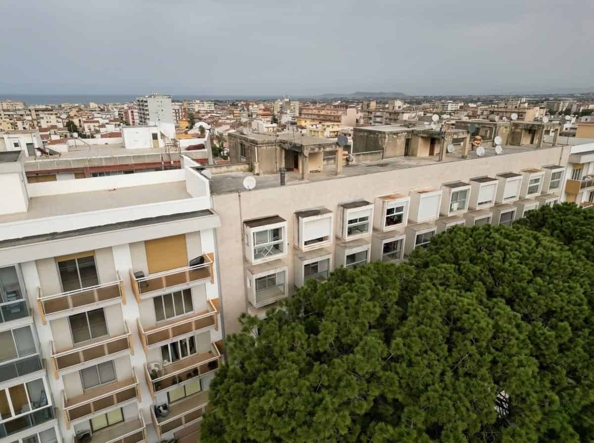 Vista panoramica di un complesso residenziale con alberi e edifici urbani, immagine di alta qualità per annunci immobiliari NextCasa.