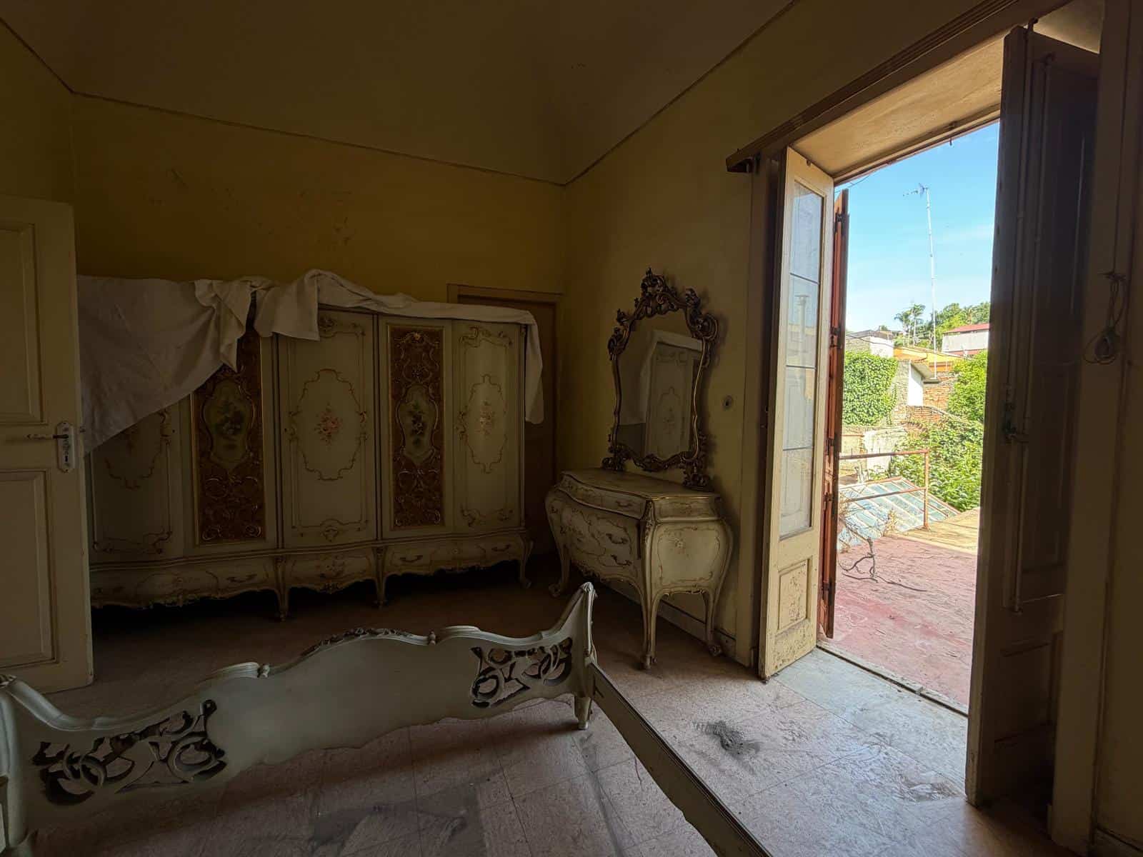Camera da letto con mobili d'epoca e accesso a balcone con vista su Barcellona P.G.