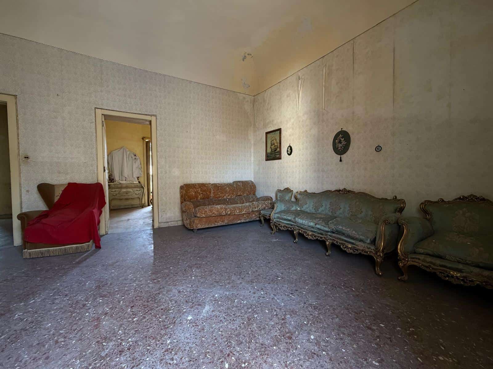 Ampio salotto con mobili d'epoca e pareti decorate, in una casa in vendita a Barcellona P.G.