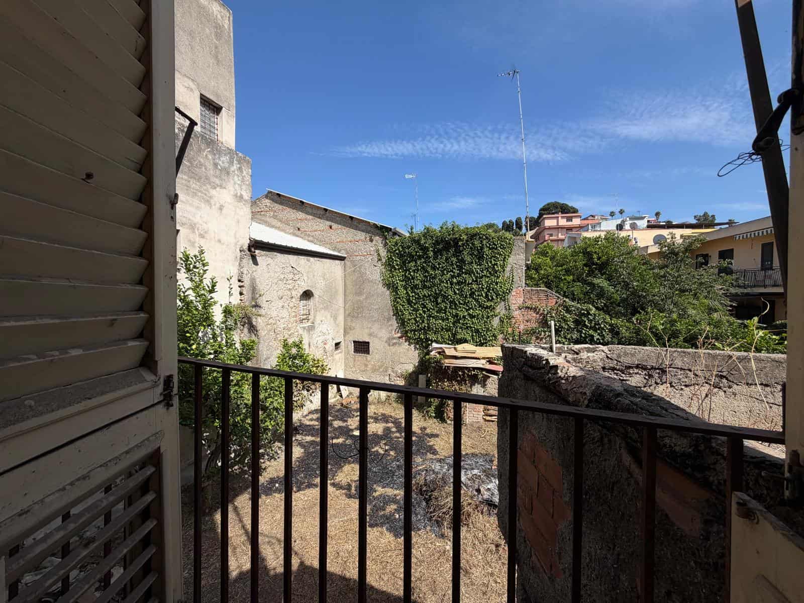 Vista dal balcone di una casa in vendita in Via Giuseppe Garibaldi, Barcellona P.G., con edifici e cielo azzurro.