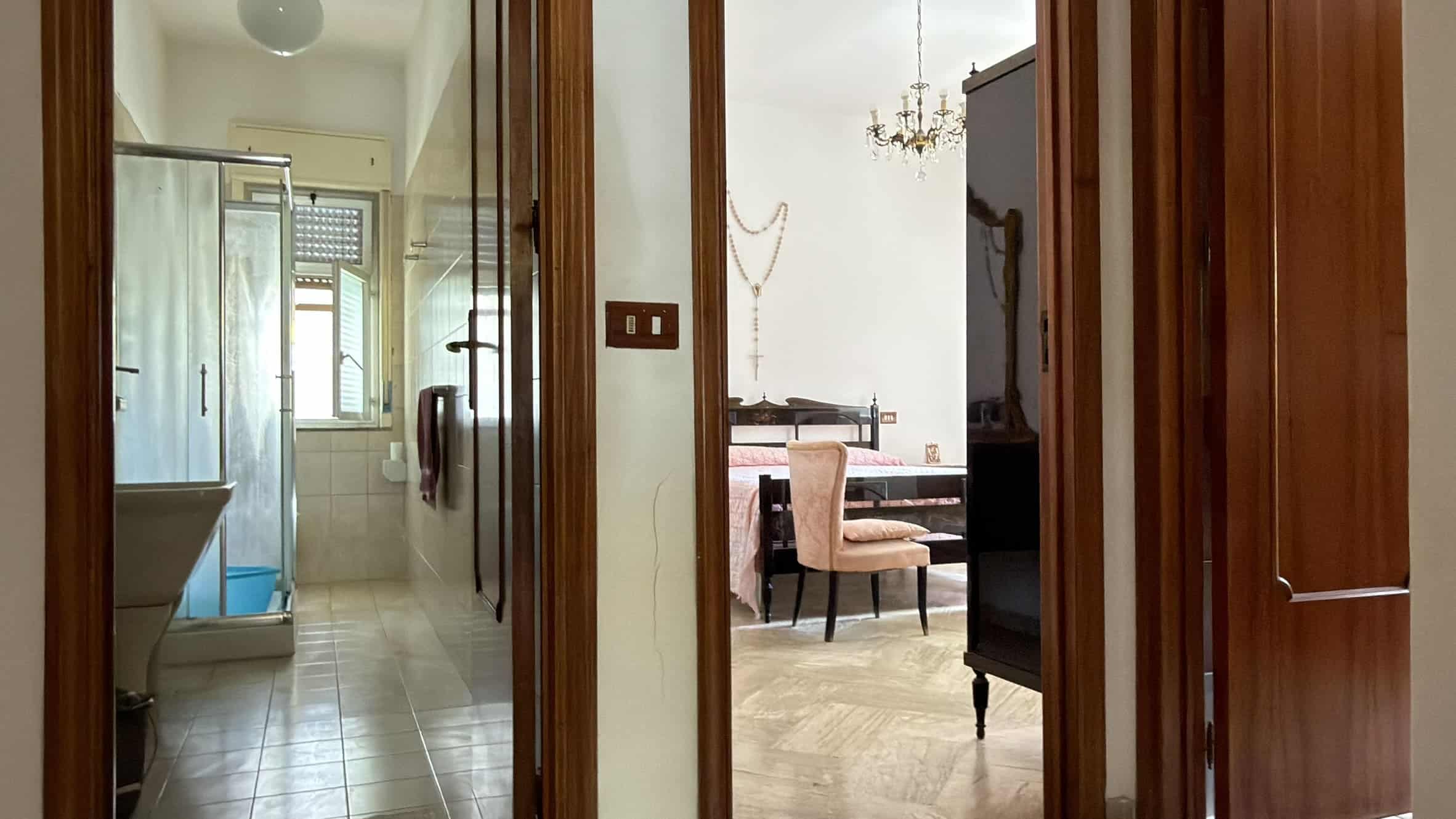 Interno di un appartamento con vista sulla zona giorno e sulla cucina, con arredi eleganti e dettagli di design.