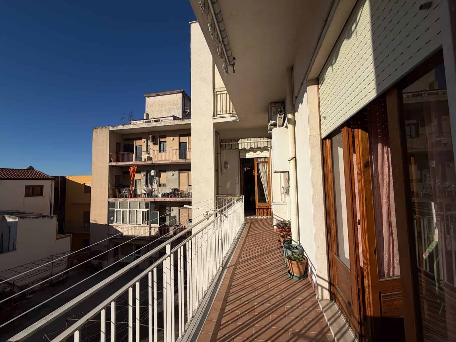 Balcone di un appartamento in vendita a Barcellona P.G. con vista su edifici circostanti e cielo sereno.