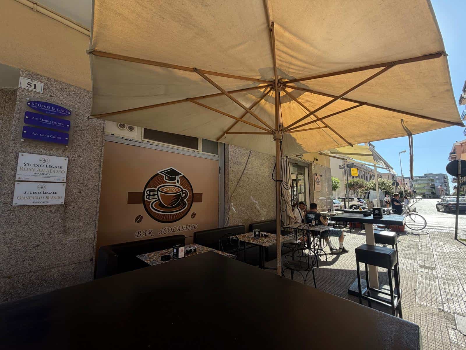 Terrazza esterna di un bar con ombrellone grande e tavoli all'aperto in Via Risorgimento a Milazzo.