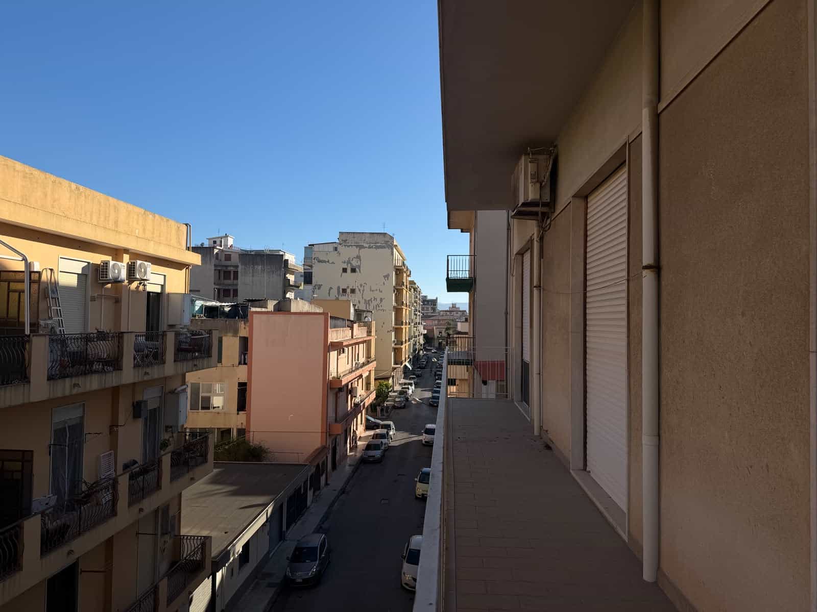Vista di un quartiere residenziale a Barcellona P.G. con edifici e strada principale.