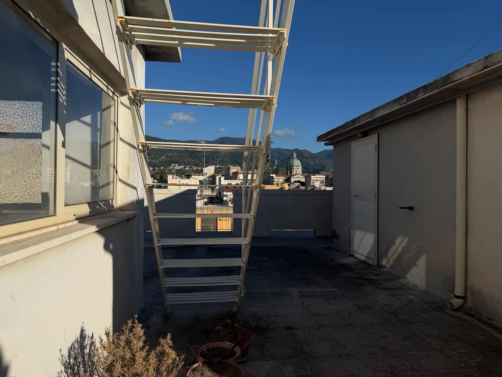 Terrazza con scala esterna e vista sulla città di Barcellona P.G. in Sicilia.