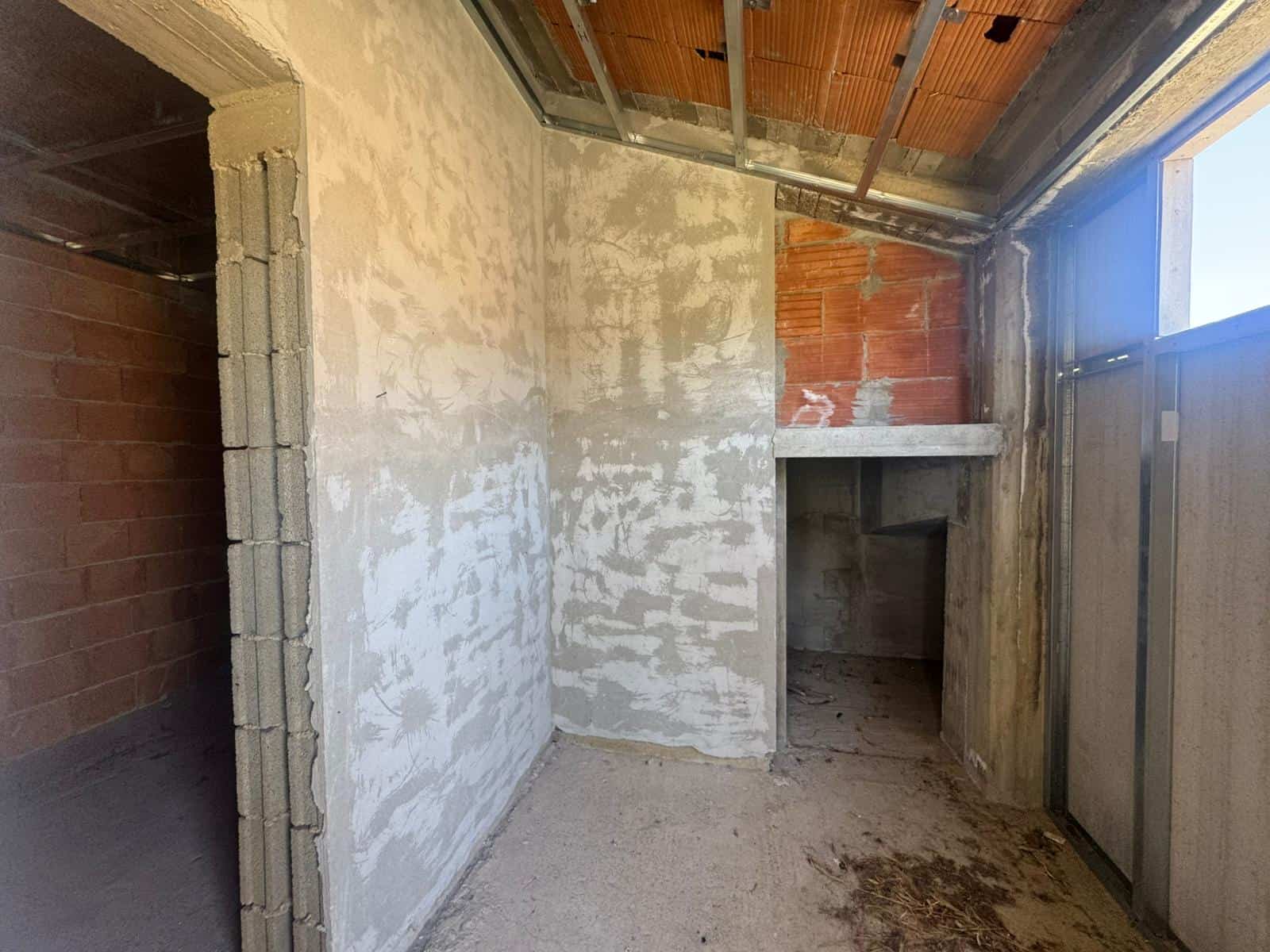 Interno di un edificio in costruzione con pareti in fase di finitura e finestre installate.