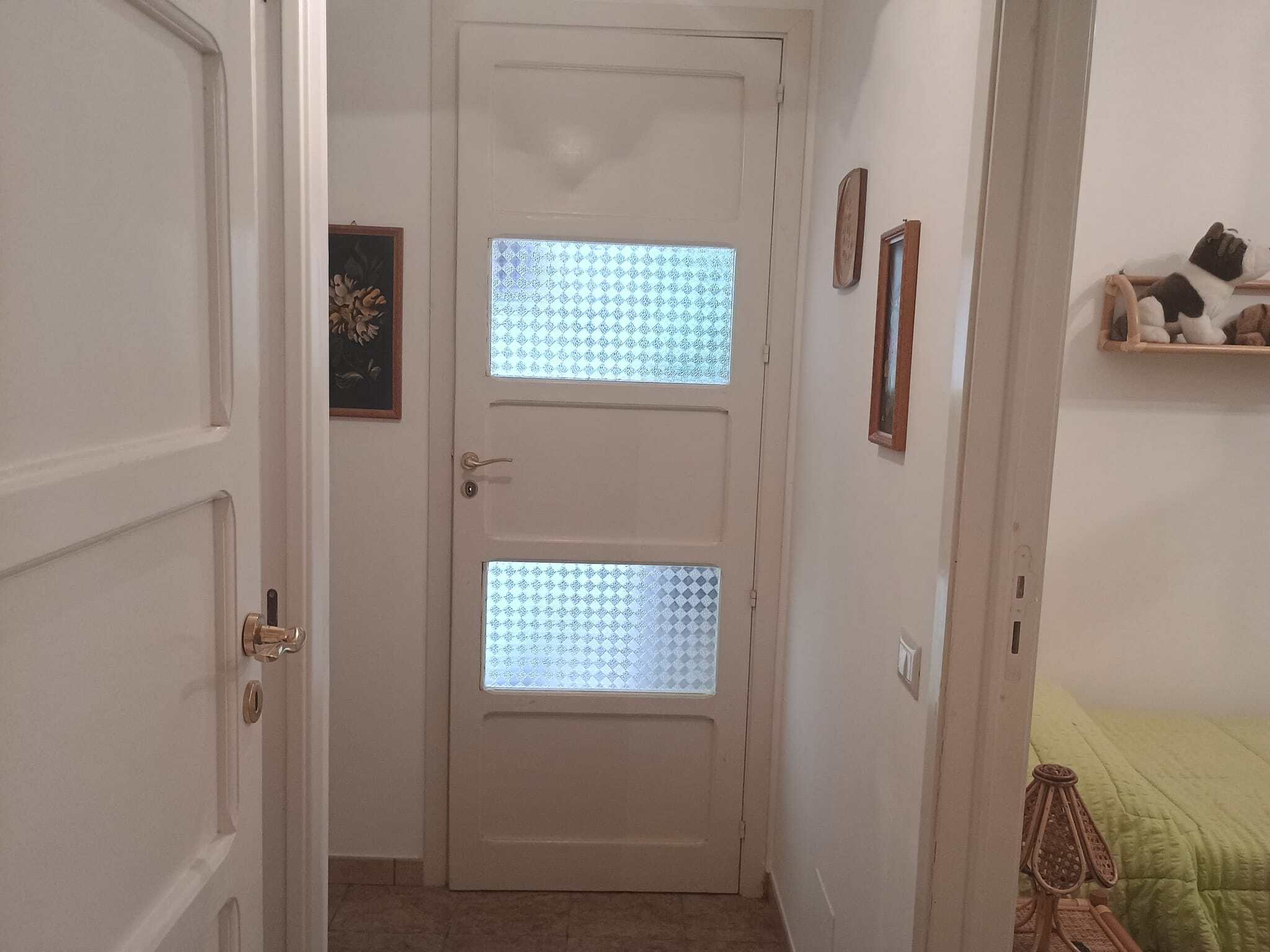 Porte interna in stile moderno con pannelli in vetro decorativo, ambiente luminoso e accogliente, ideale per abitazioni eleganti e funzionali.