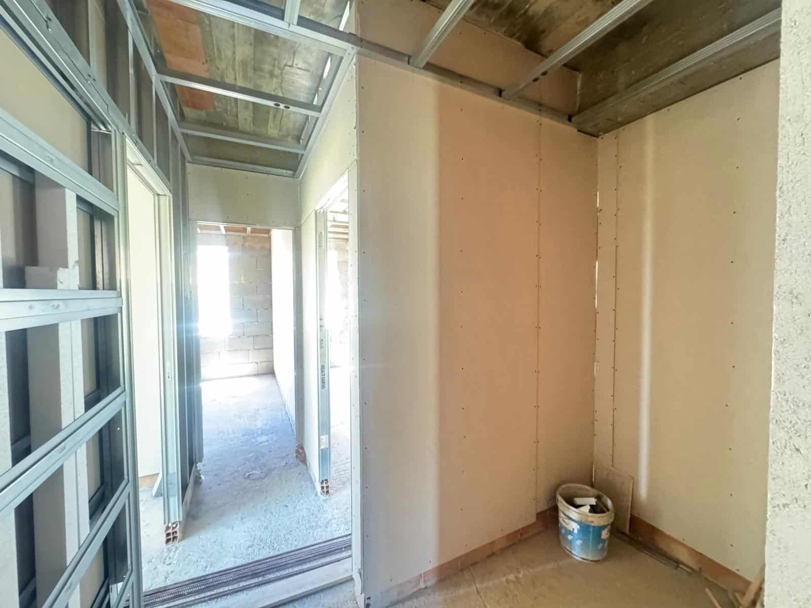 Interno in costruzione di un appartamento con pareti in cartongesso e struttura in acciaio, pronto per finiture e installazioni.
