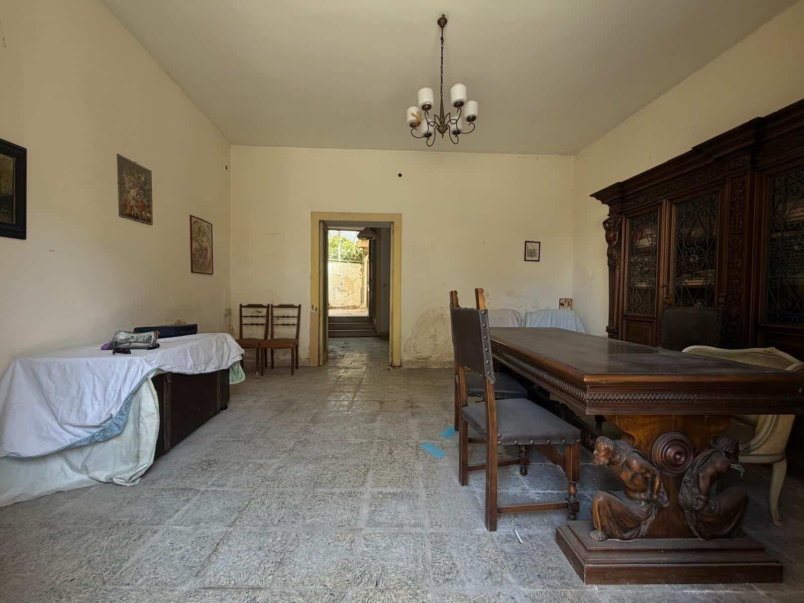 Interno di una casa indipendente con mobili d'epoca e pareti decorate, ideale per chi cerca un'abitazione storica in vendita a Barcellona P.G.