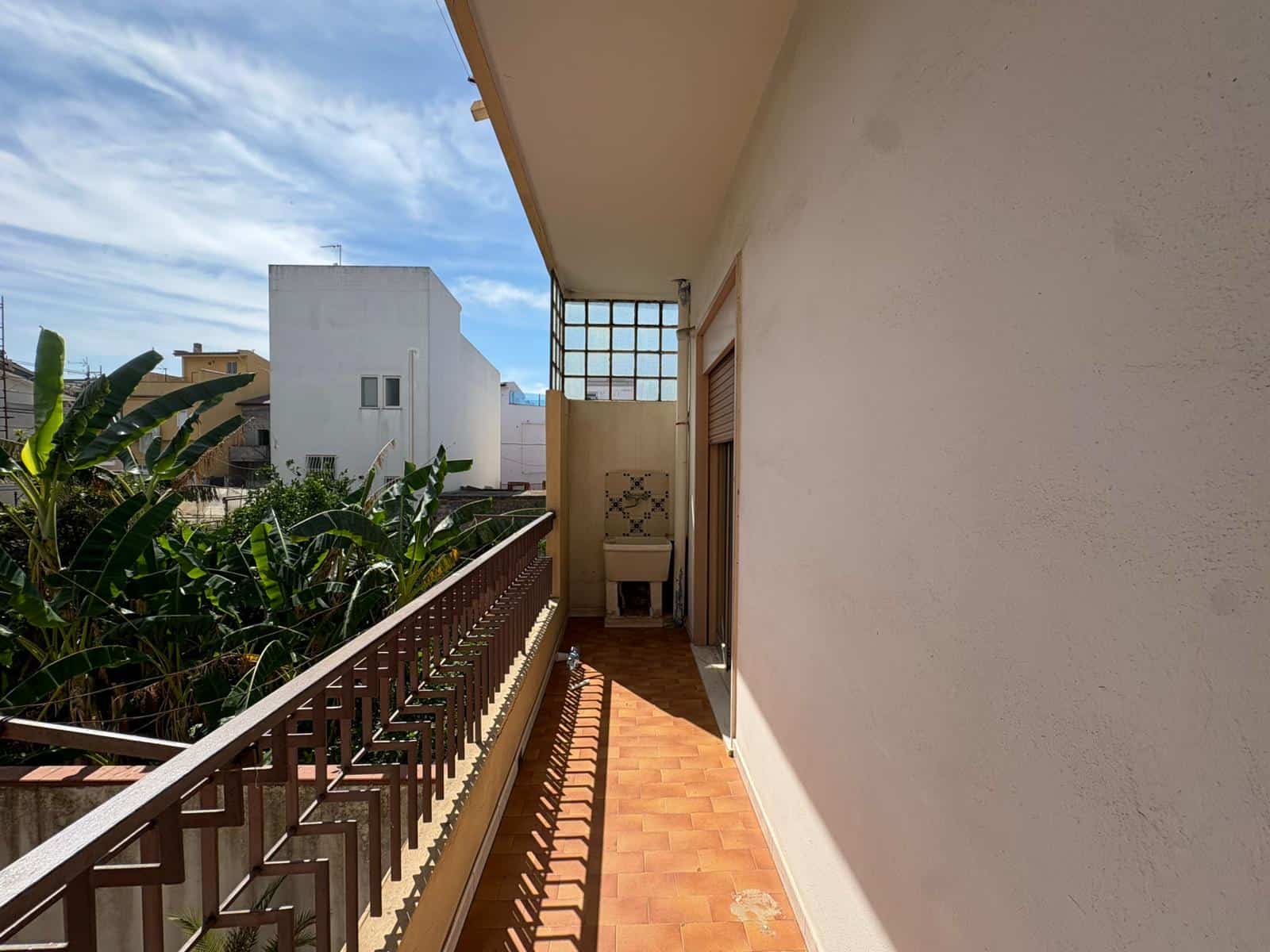Balcone di un appartamento in vendita a Merì con vista su edifici e cielo sereno.