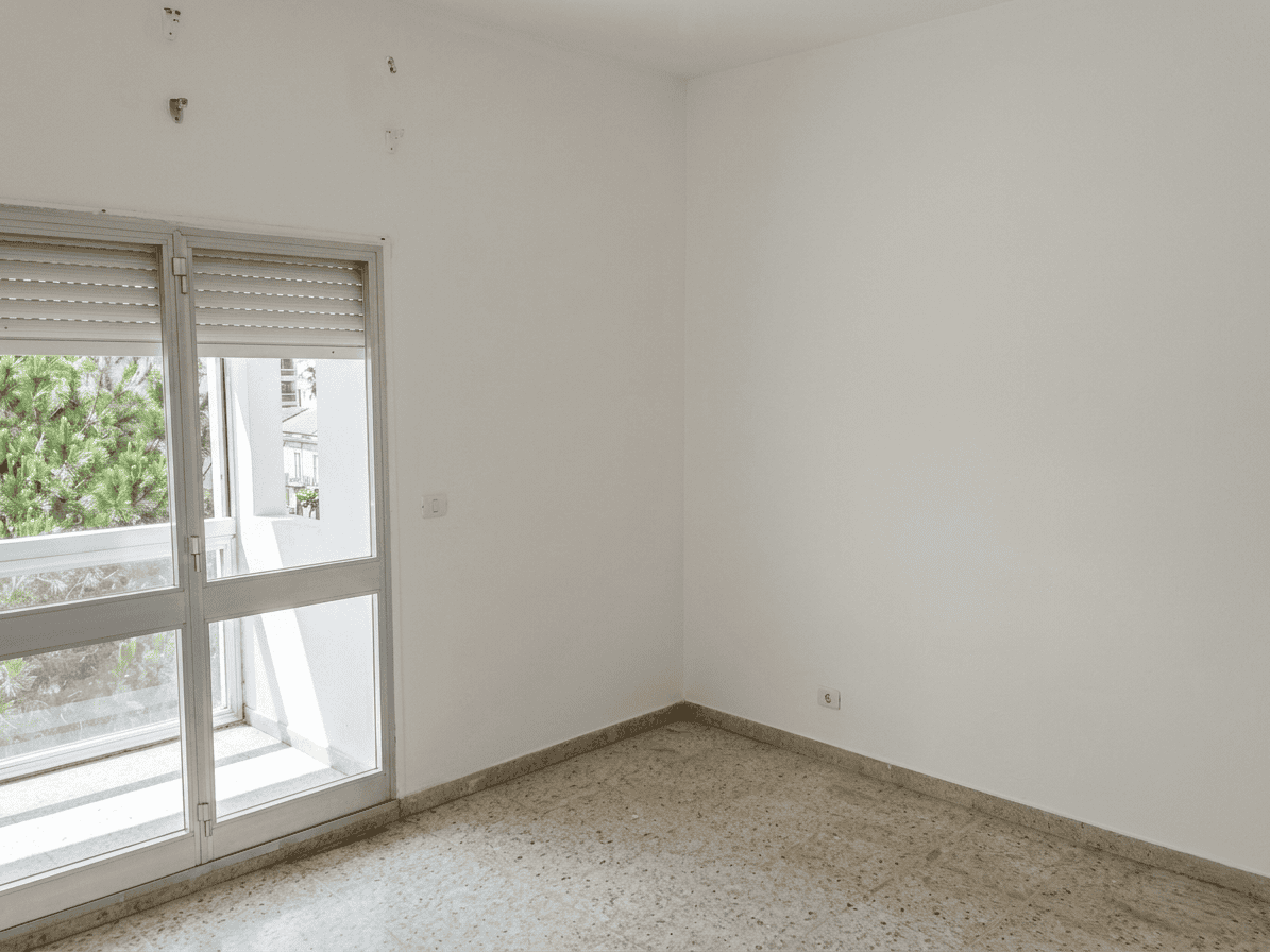 Appartamento vuoto con balcone e luce naturale, ideale per ristrutturazione e personalizzazione. Perfetto per chi cerca un ambiente luminoso e spazioso in zona residenziale.