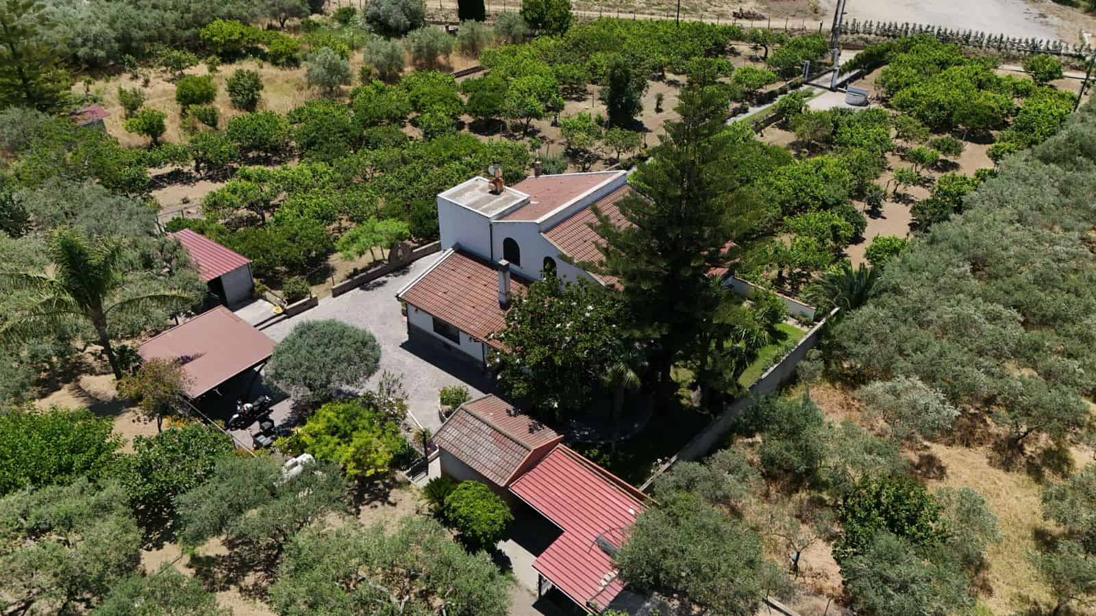 Vista aerea di una villa singola circondata da un ampio giardino con alberi e strutture esterne in Contrada Rosa, Terme Vigliatore, Me.
