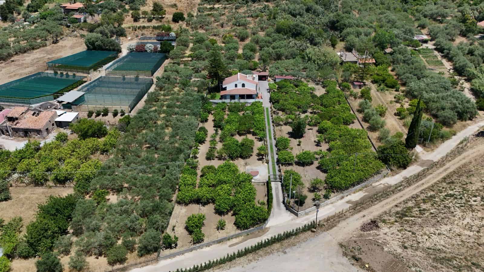 Vista aerea di una villa singola con ampi terreni e campi da tennis a Terme Vigliatore, Sicilia.