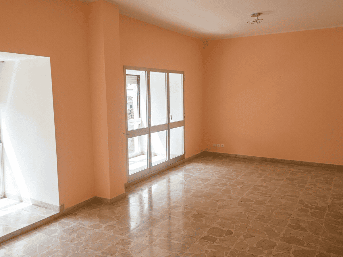 Appartamento spazioso con pareti color pesca, grandi finestre e balcone, ideale per vivere in comfort. Perfetto per chi cerca una casa luminosa e accogliente in zona residenziale.