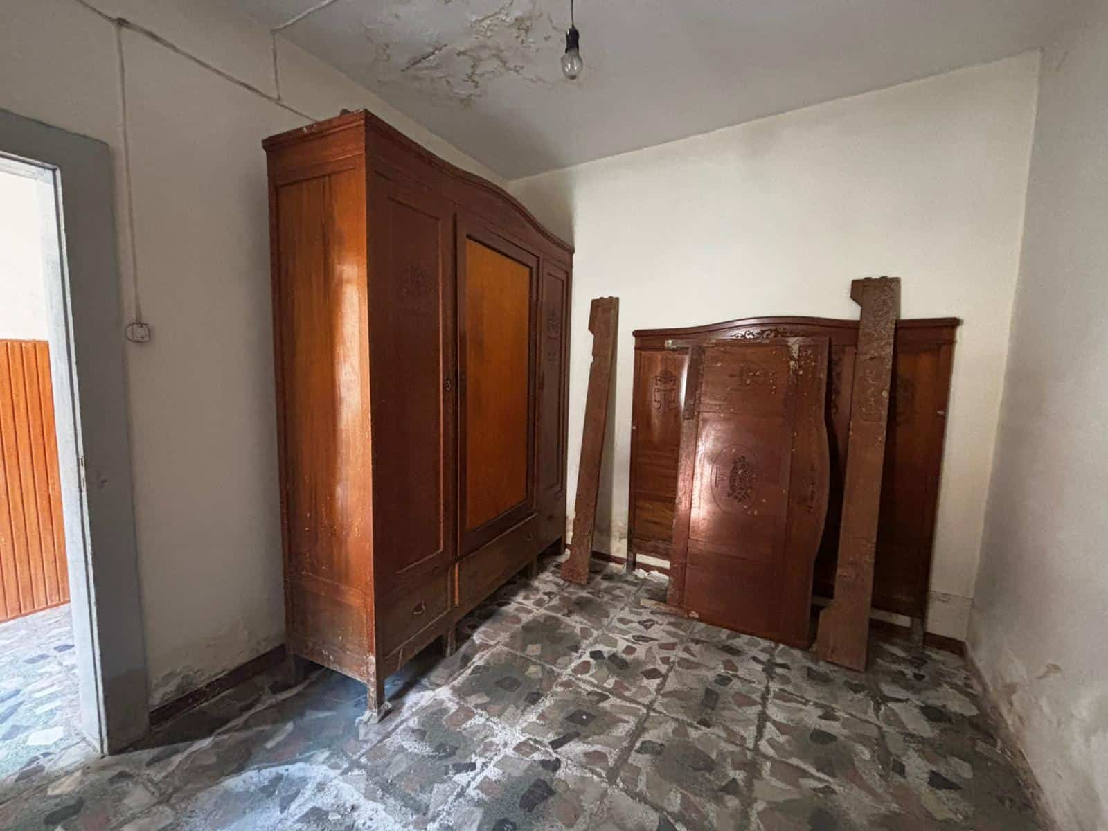 Anticamera in stile rustico con mobili in legno massiccio, pavimento in pietra naturale, ambiente accogliente e tradizionale. Perfetta per ingressi di case di campagna o rustici ristrutturati.