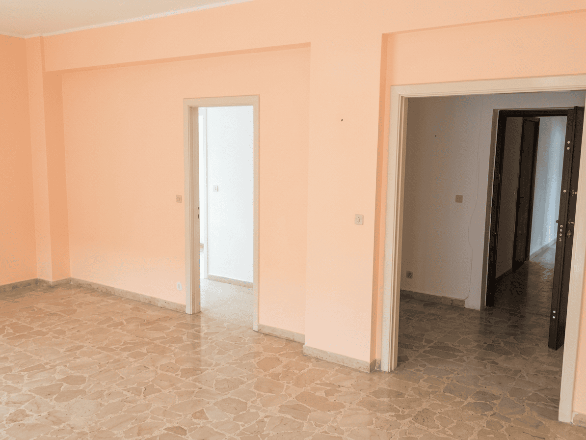 Interno di un appartamento con pareti rosa e pavimento in marmo, vista su stanze e corridoio, ideale per annunci immobiliari NextCasa.