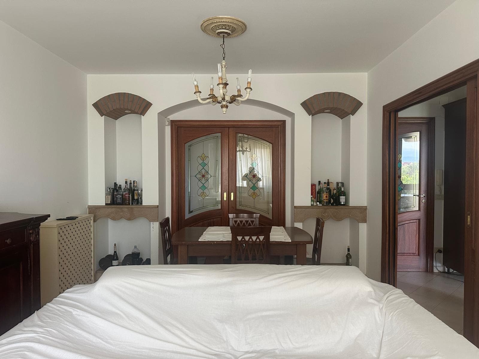 Interno di un appartamento in vendita a Milazzo, vista sulla zona pranzo con tavolo e sedie, arredamento classico e dettagli eleganti.
