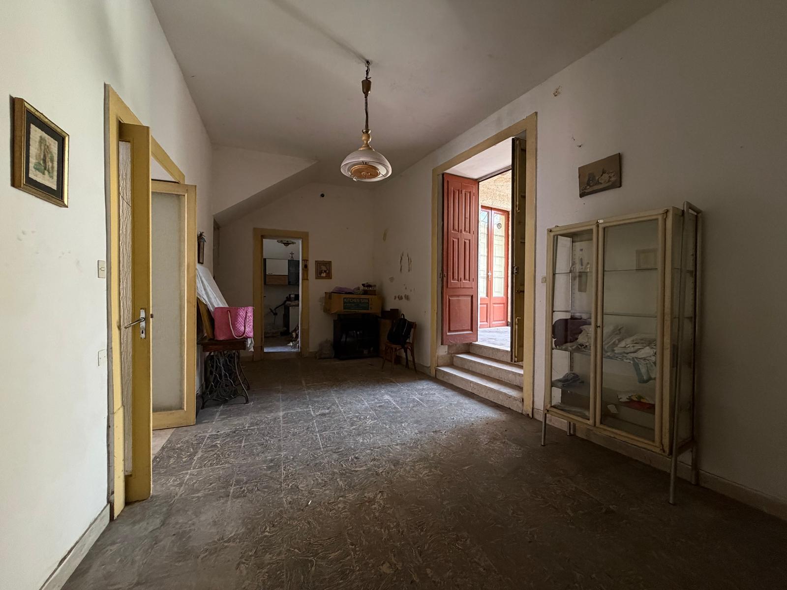 Interno di una casa indipendente in vendita a Barcellona P.G., con ingresso, soggiorno e accesso al balcone.