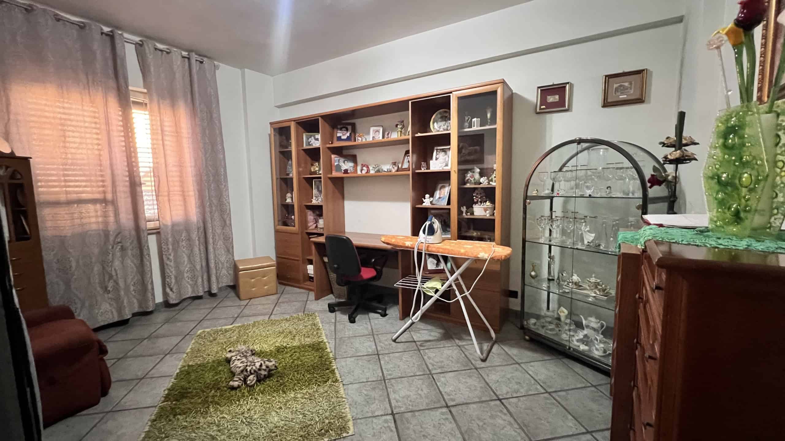 Interno di una villa unifamiliare con scrivania, libreria, e arredi classici in stile tradizionale.