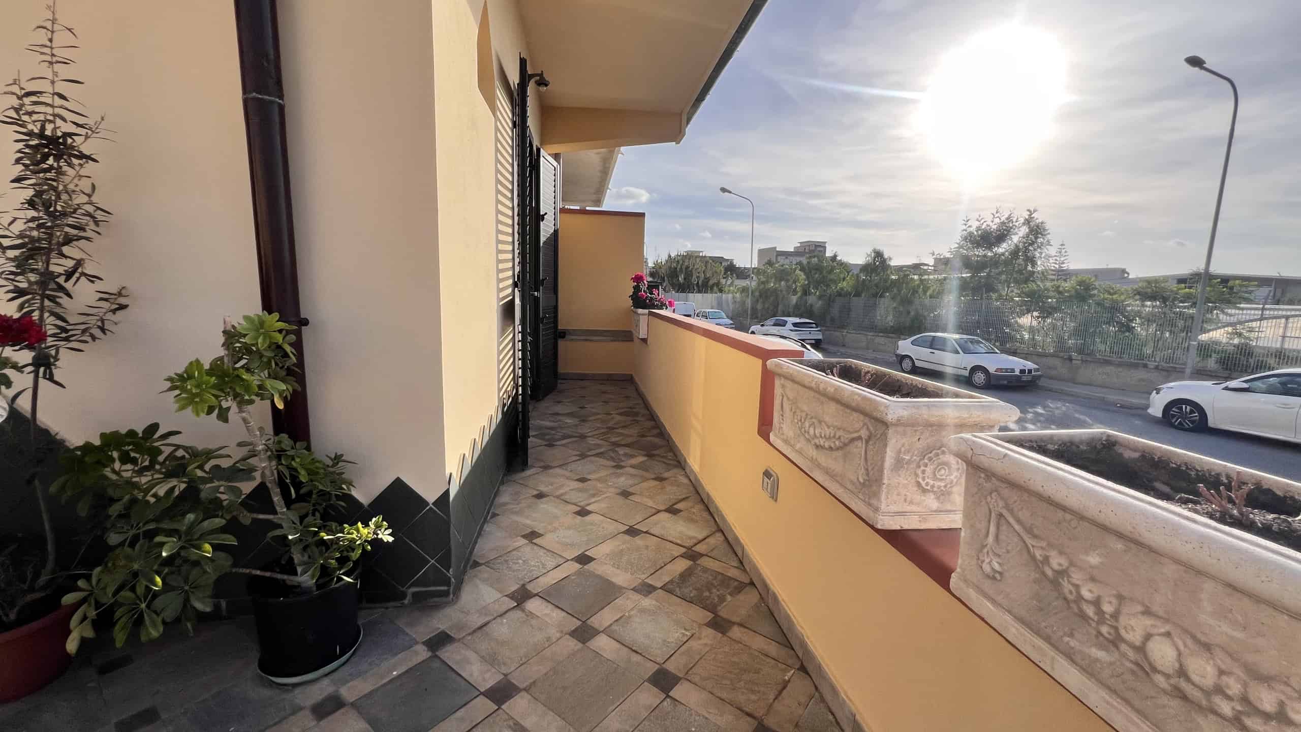 Balcone di una villa unifamiliare in vendita a Villafranca Tirrena con vista sulla strada e parcheggio.