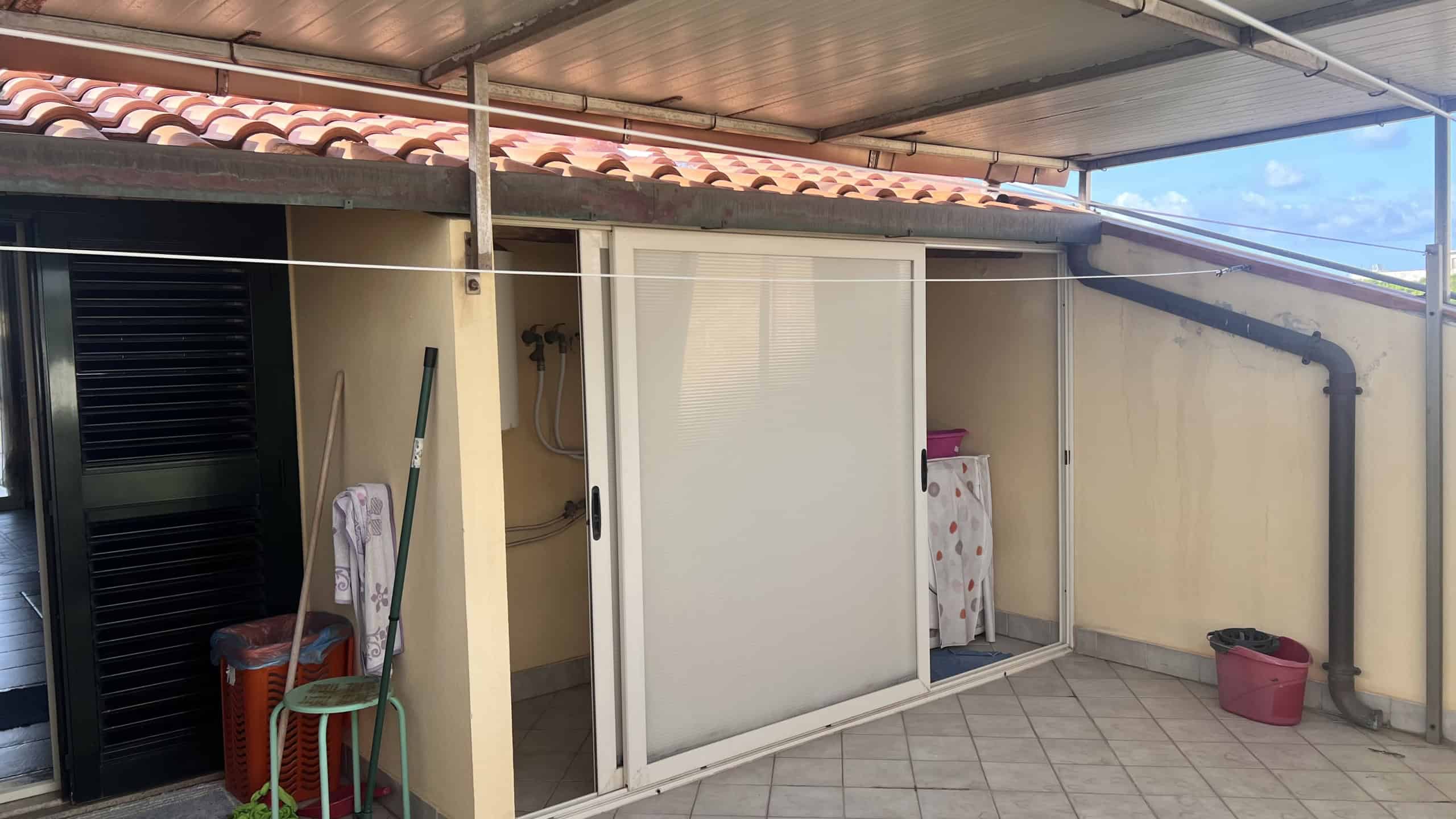 Balcone con area coperta e accessori per il bucato, vista sulla zona esterna di una villa in vendita a Villafranca Tirrena.