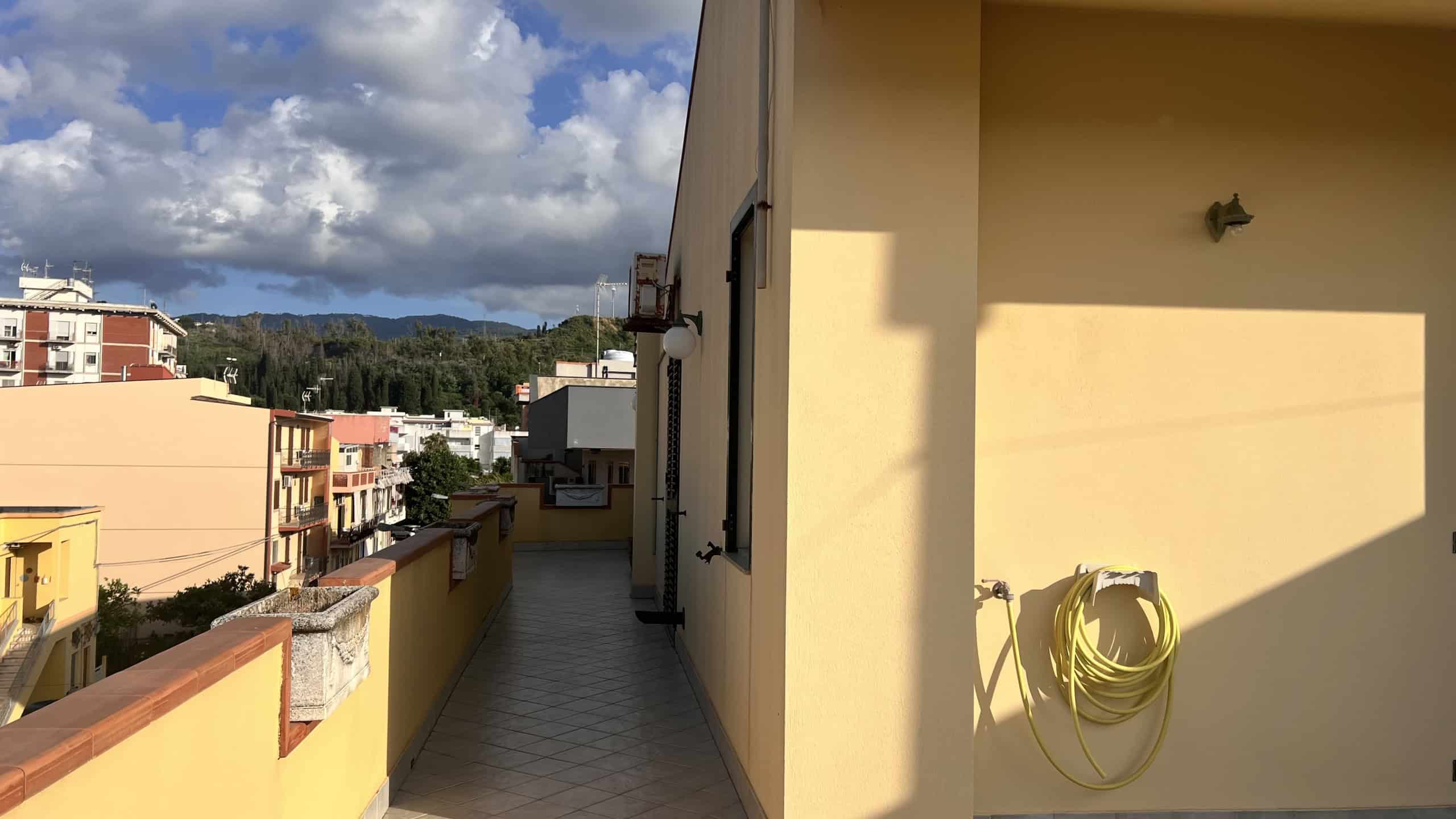 Balcone di un appartamento con vista sulla città e sul cielo nuvoloso, in zona residenziale di Villafranca Tirrena.