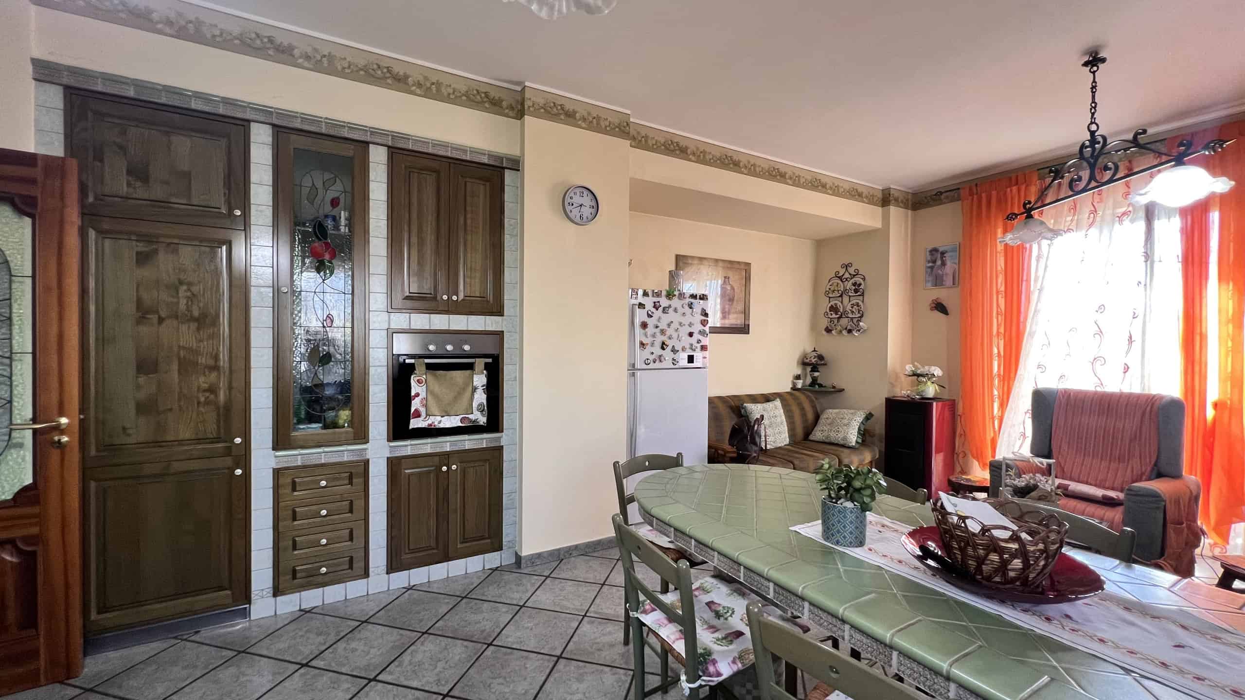 Interno di una villa con soggiorno e zona pranzo, arredi classici e decorazioni eleganti.