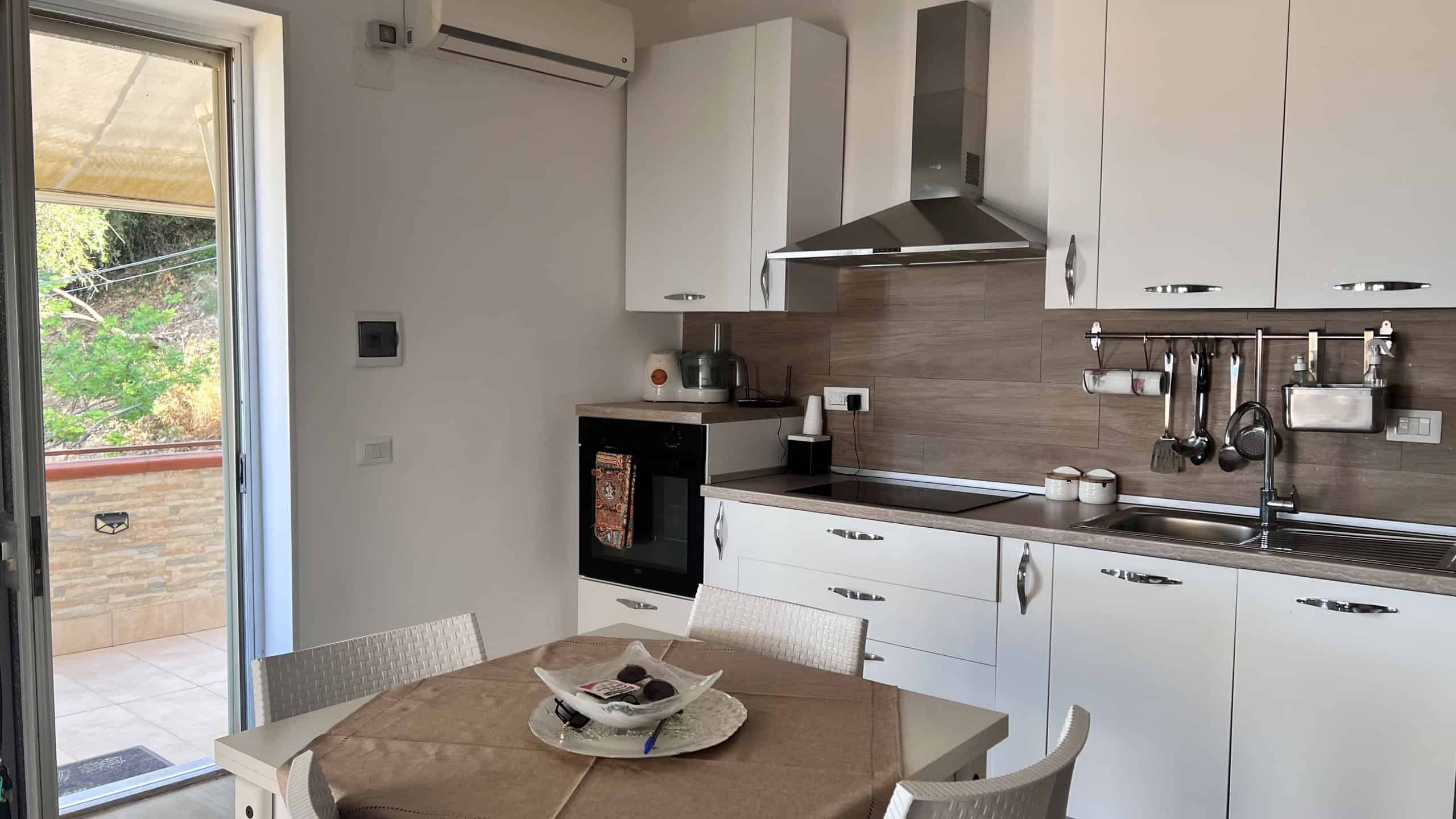 Cucina moderna con elettrodomestici e piano di lavoro in un appartamento in vendita a Acqualadroni, Me.