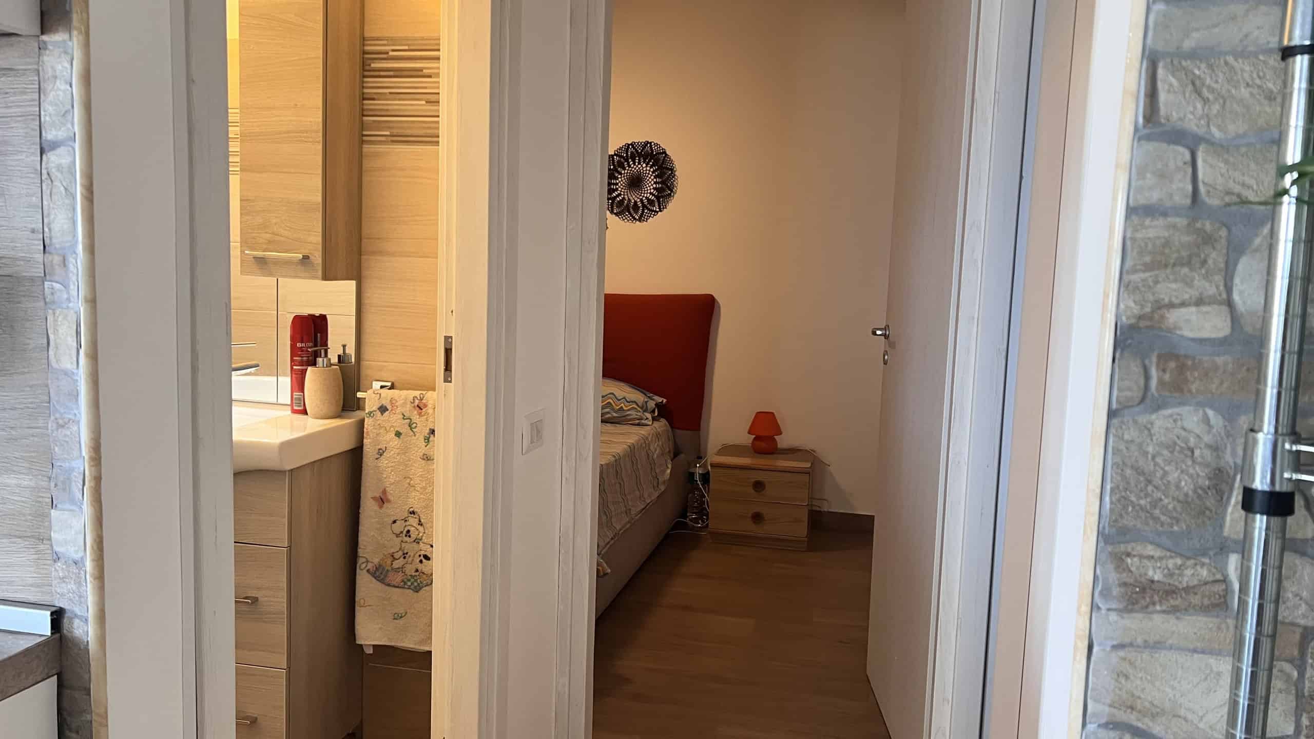 Interno di una camera da letto moderna con letto, comodino e decorazioni.