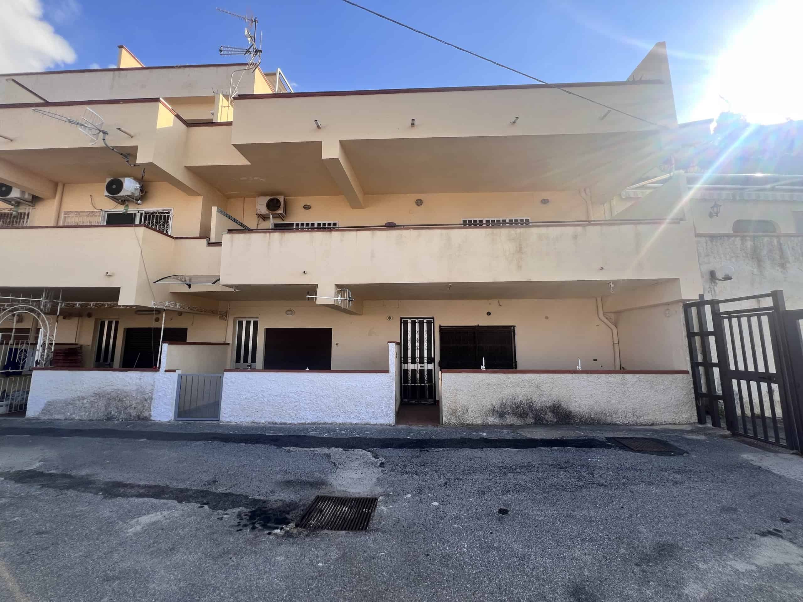 Facciata di un appartamento in vendita in Via Del Corsaro 81, Acqualadroni, con balconi e accesso pedonale, sotto un cielo sereno.