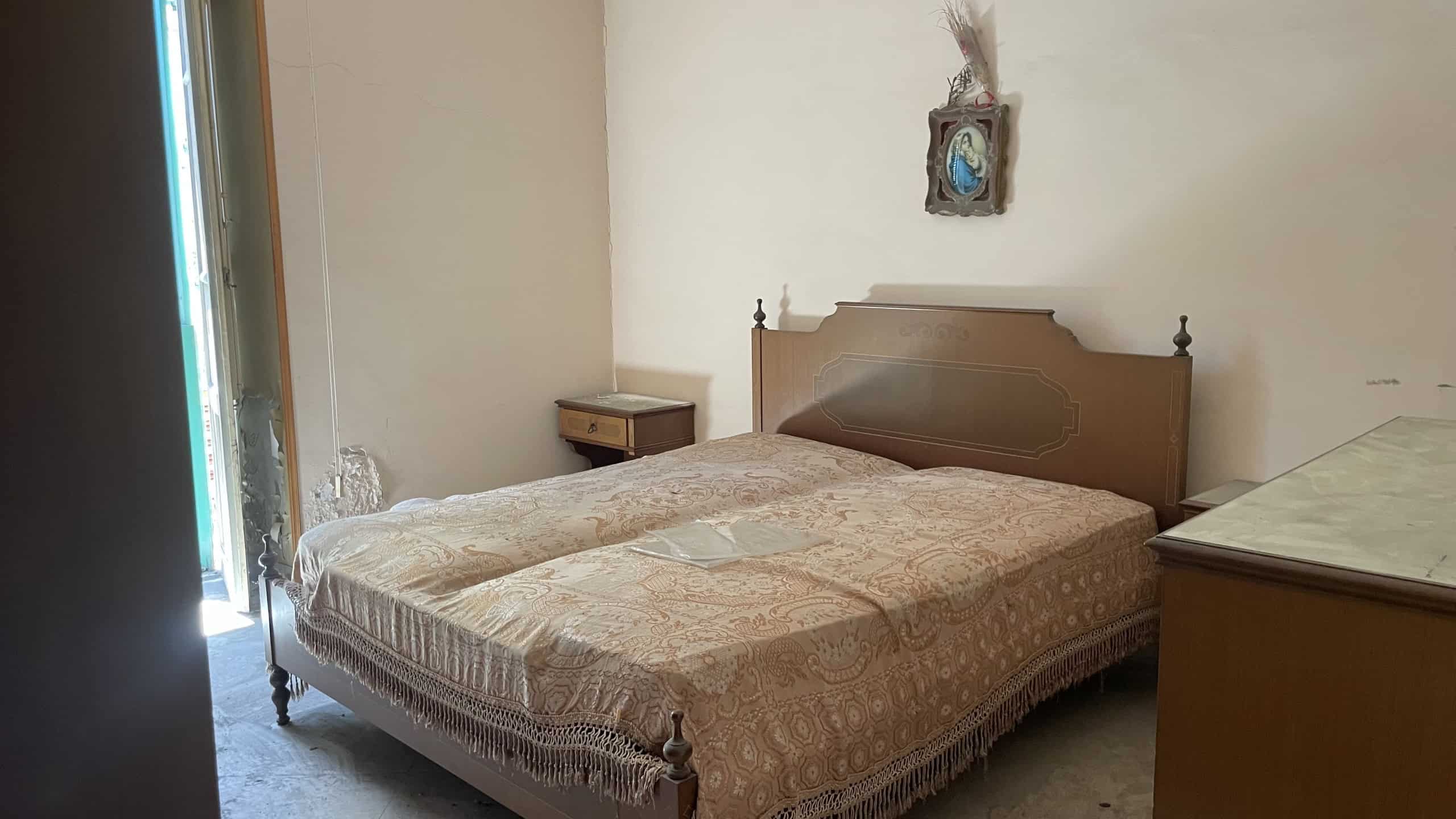Camera da letto con letto matrimoniale, comodino e armadio in appartamento a Scaletta Zanclea, Me.