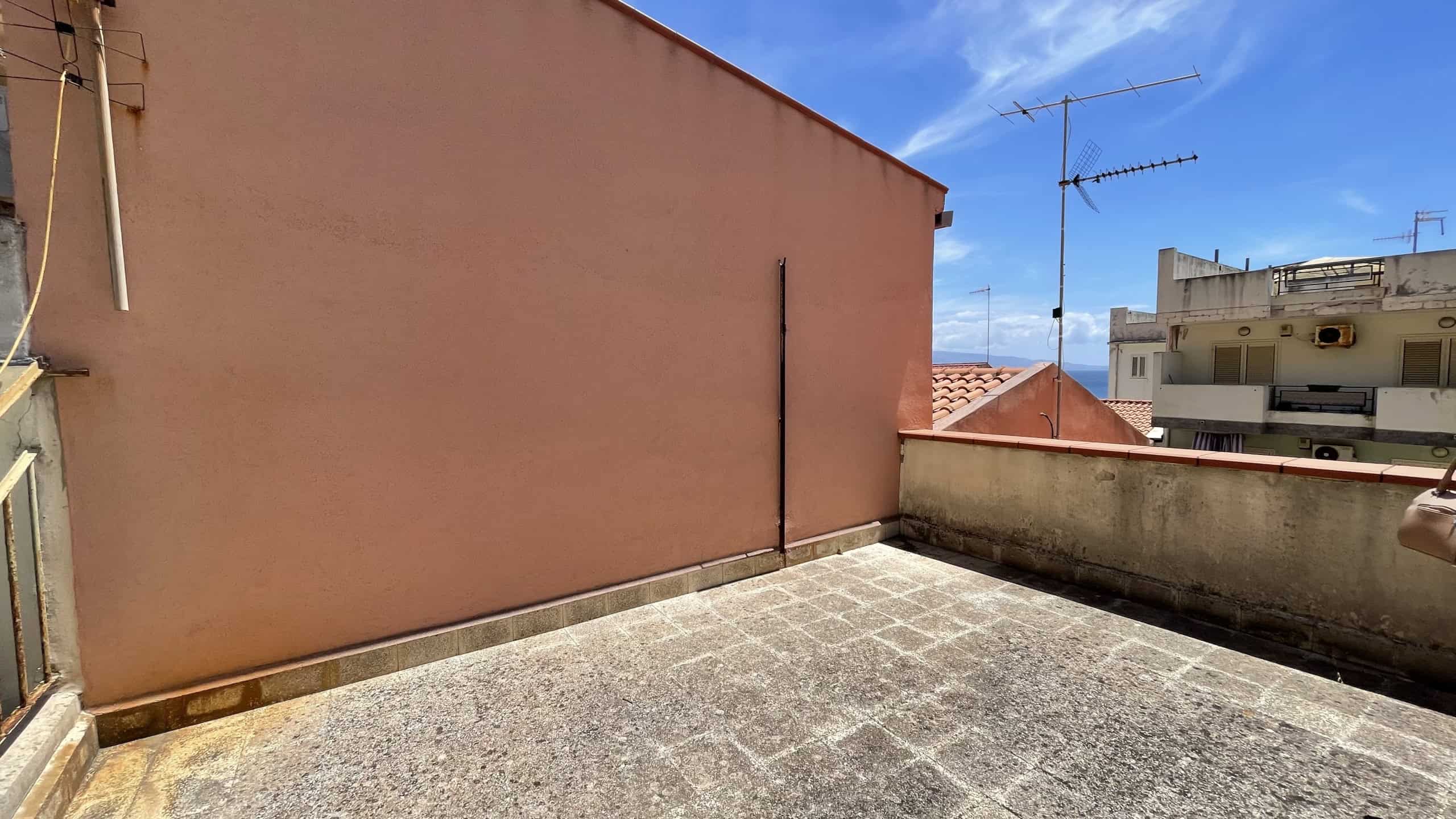 Terrazza all'aperto con vista sulla città di Scaletta Zanclea, ideale per relax e socializzazione all'aperto.