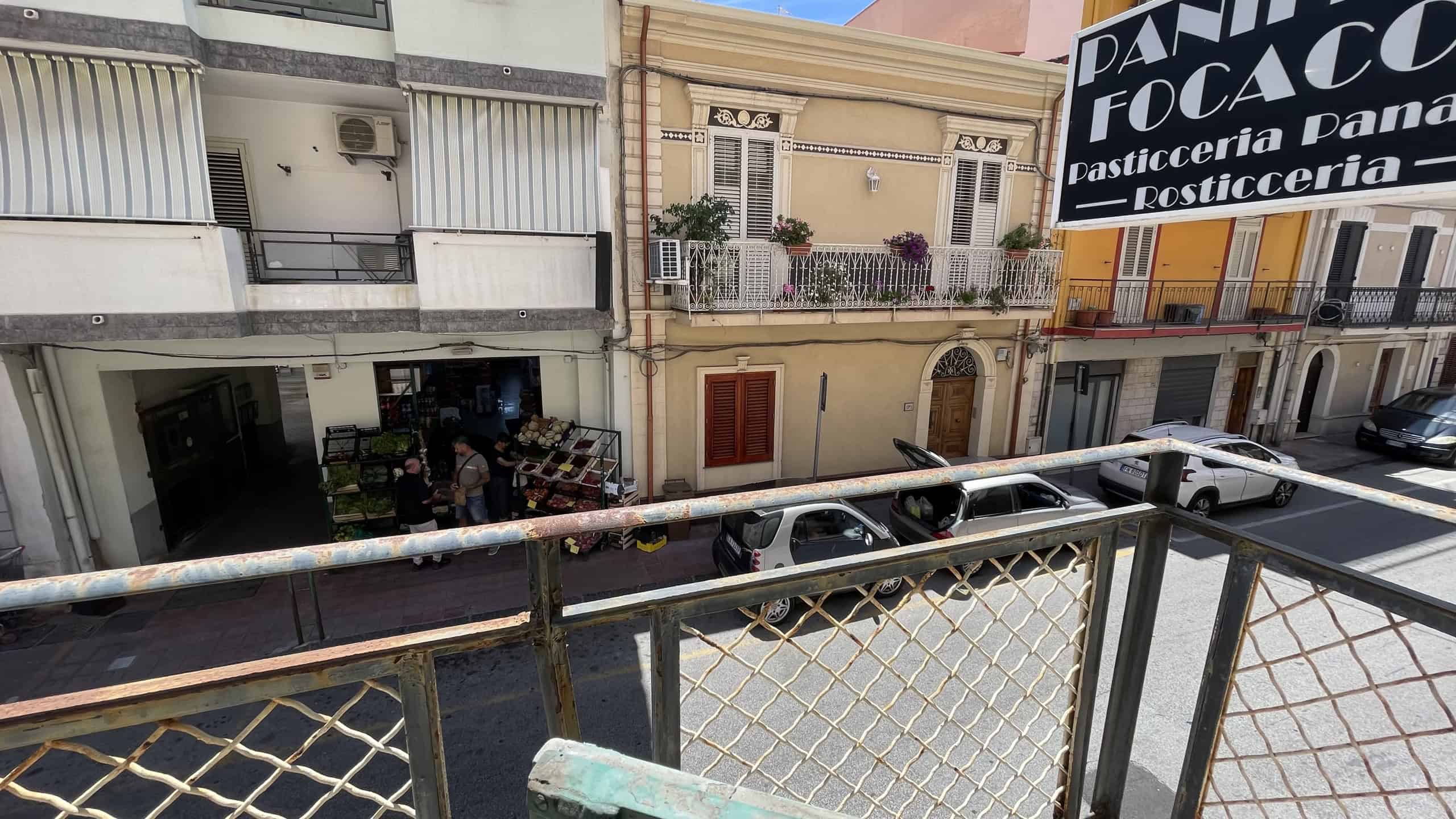 Vista dal balcone di Scaletta Zanclea con auto parcheggiate e edifici storici.
