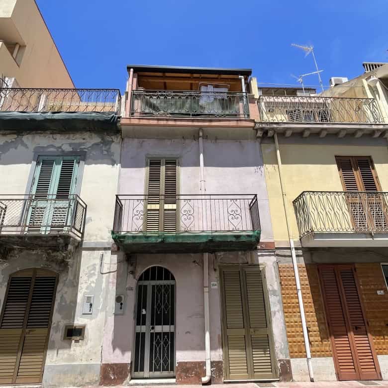 Facciata di un edificio residenziale in Via Roma 168, Scaletta Zanclea, con balconi e finestre, sotto un cielo blu.