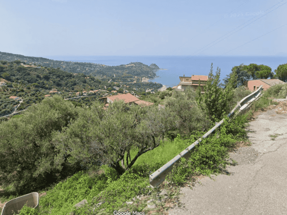 Vista panoramica sulla campagna di Capo d'Orlando con vista mare in lontananza, strada asfaltata e vegetazione rigogliosa.