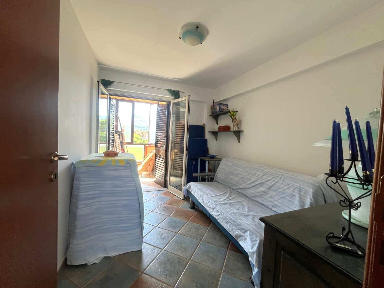 Ampia stanza con balcone, divano letto e scrivania, luminosa e accogliente, ideale per soggiorni a breve o lungo termine, con vista panoramica sulla città.
