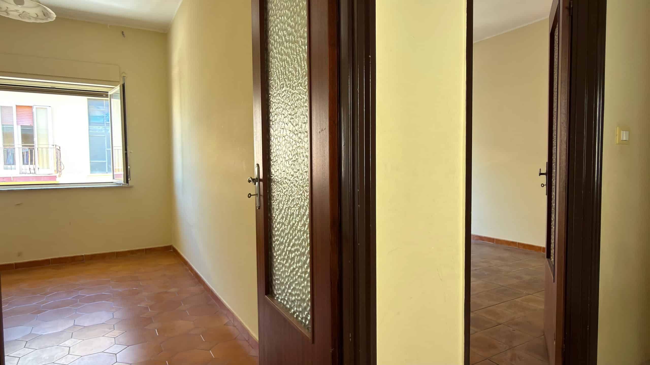 WhatsApp Image 2026-06-03 at 11.59.55 Ampia stanza luminosa con pareti beige, pavimento in piastrelle e finestra che permette l'ingresso di luce naturale, ideale per ambienti residenziali.