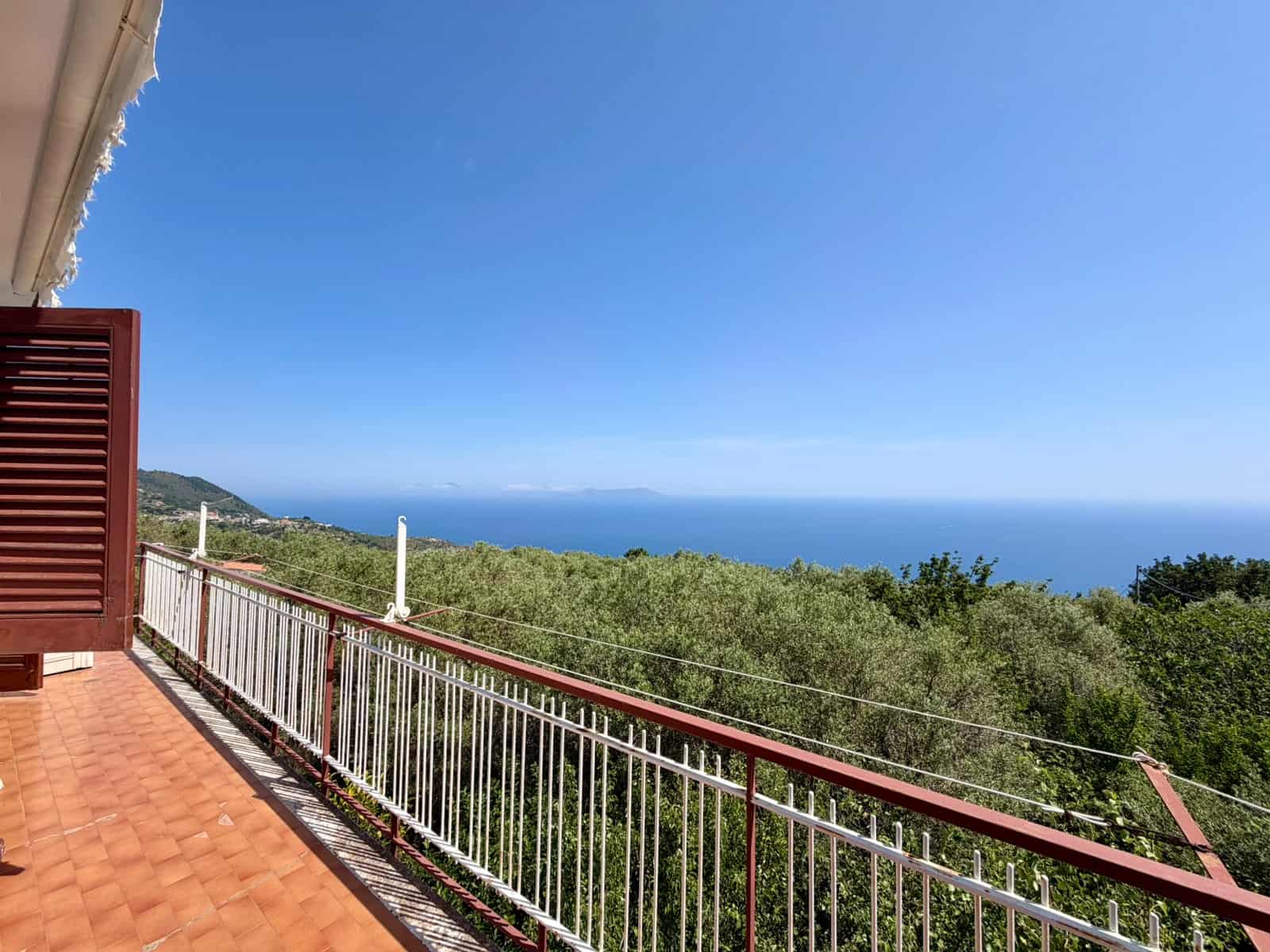 Il panorama mozzafiato dal balcone di una casa al mare con vista sull'oceano e sulla natura circostante, in Italia.
