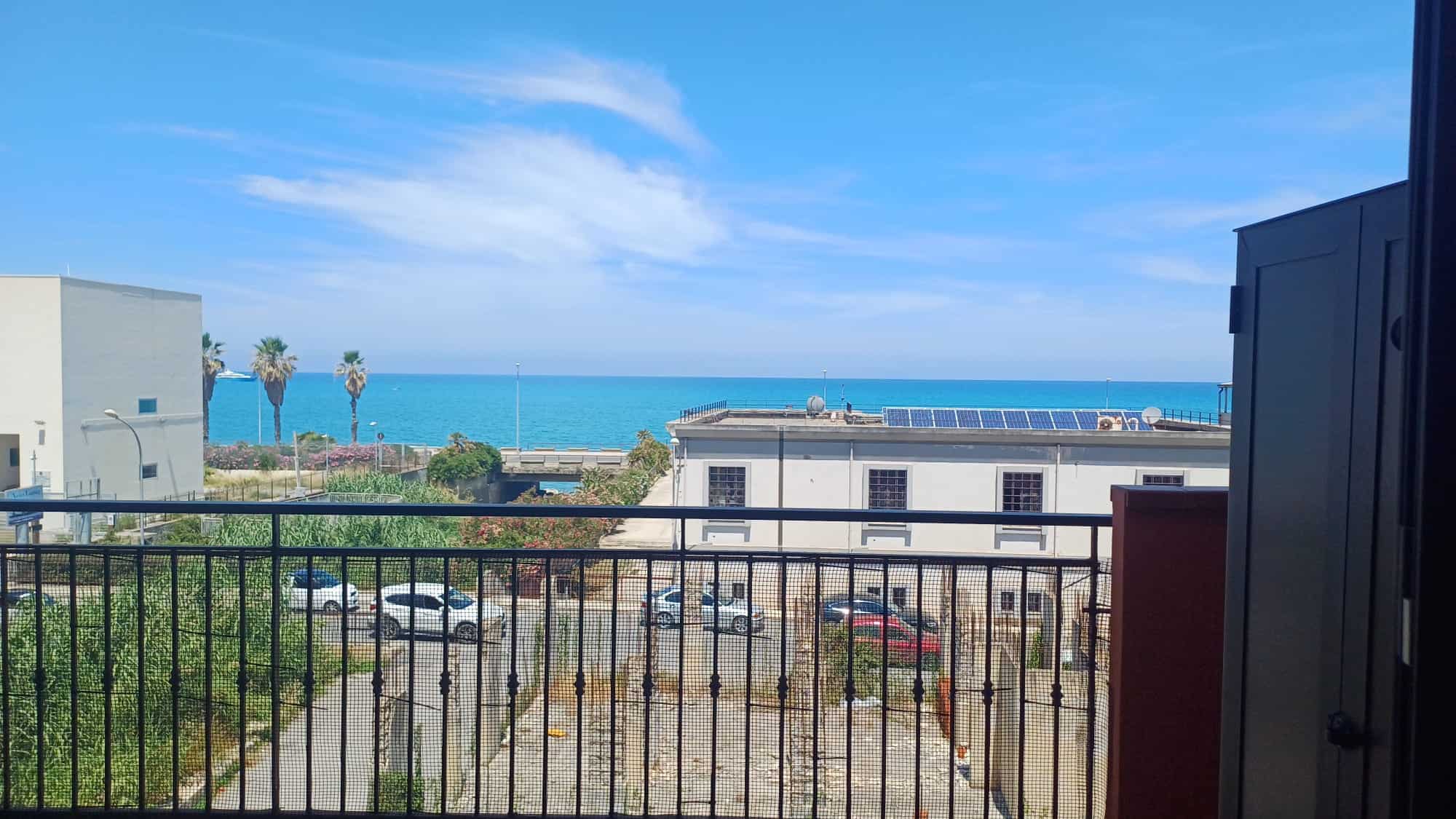 Spiaggia panoramica con vista mare, edifici moderni e area verde, ideale per immobili residenziali e investimenti immobiliari in località costiere italiane.