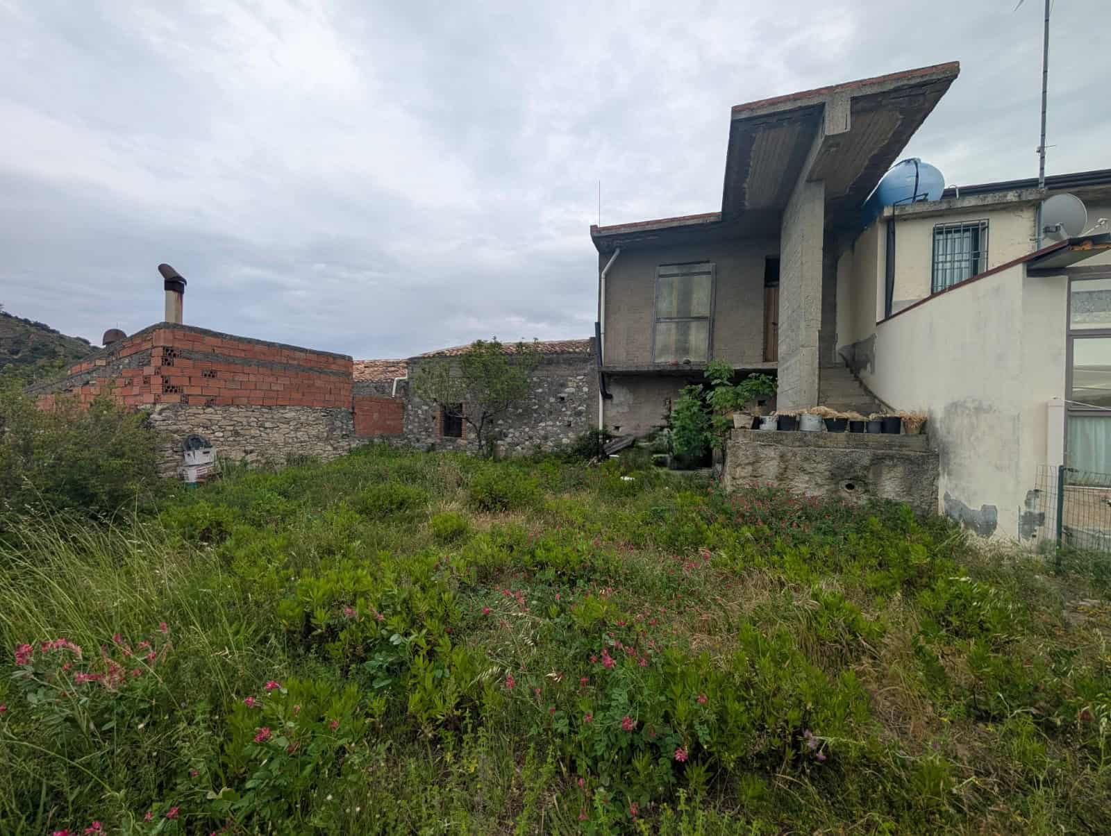 Terreno edificabile con vista su abitazioni moderne e natura, ideale per costruzioni residenziali a NextCasa, zona tranquilla e panoramica.