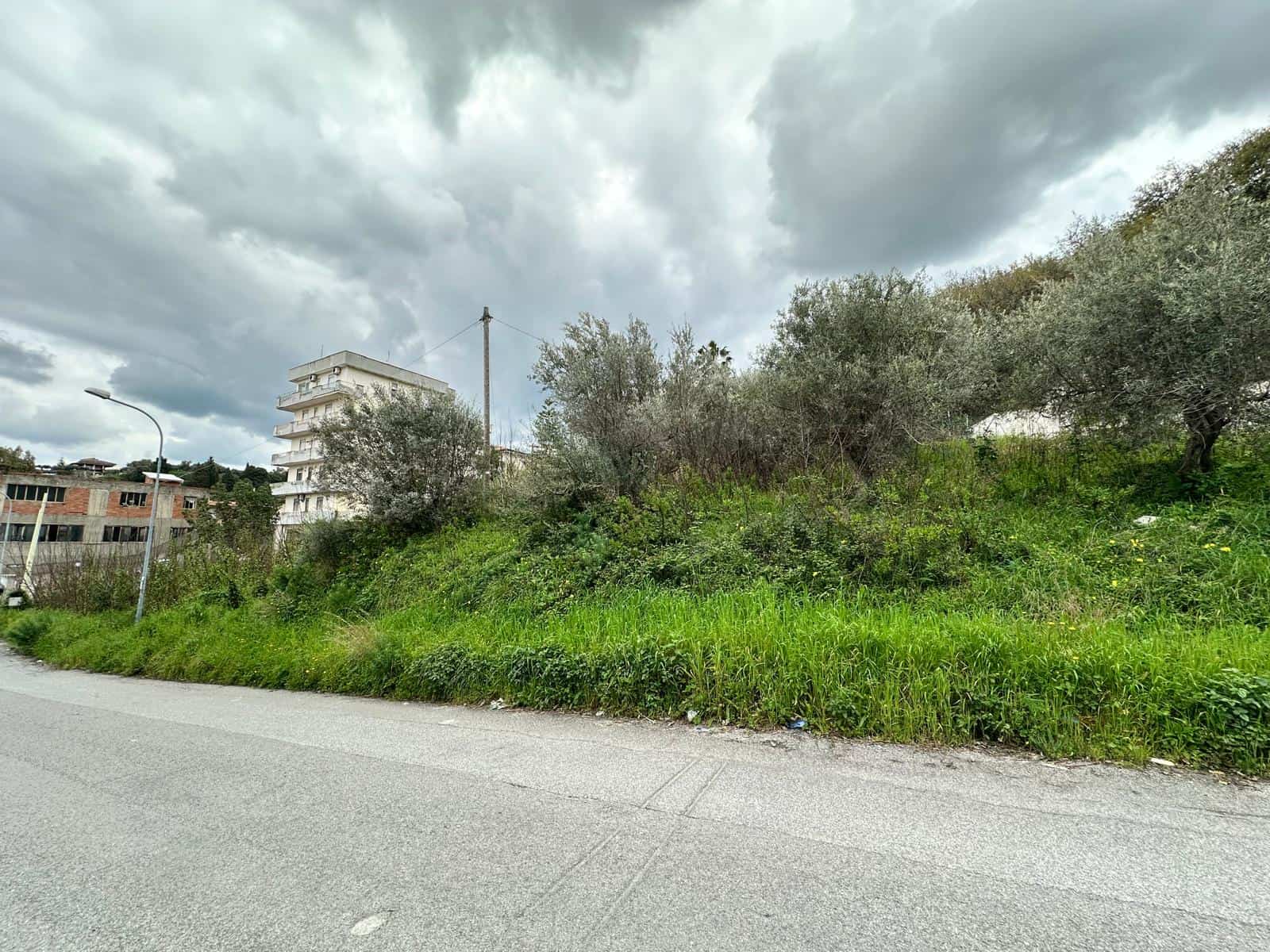 Terreno edificabile in vendita a Barcellona P.G. con vista su cielo nuvoloso e vegetazione circostante.