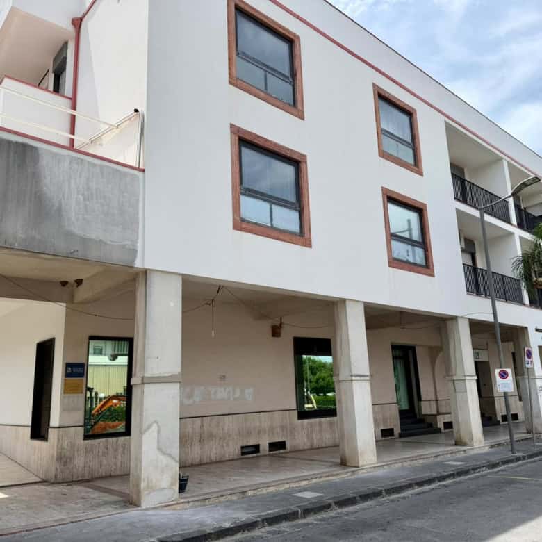 Edificio residenziale moderno con balconi e finestre grandi, situato in zona urbana, con parcheggio e area pedonale, in stile contemporaneo, ideale per investimenti immobiliari a NextCasa.