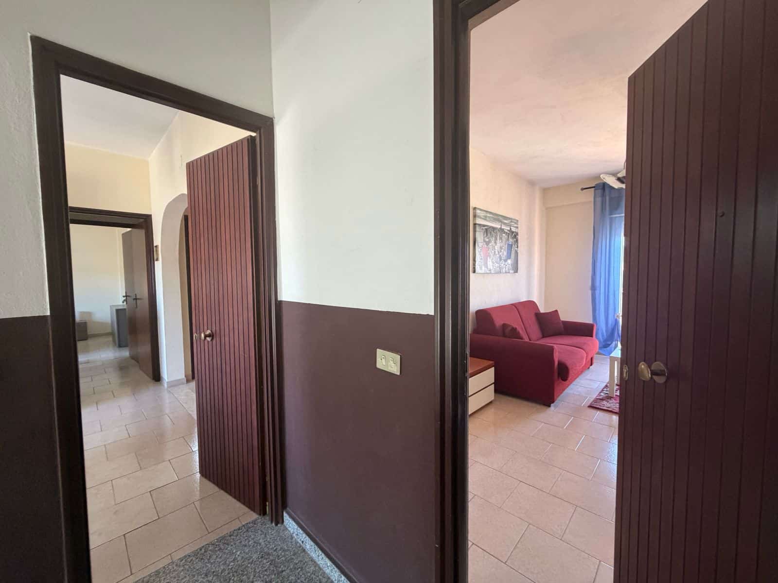 Interno di un appartamento a Terme Vigliatore con ingresso e soggiorno arredato.