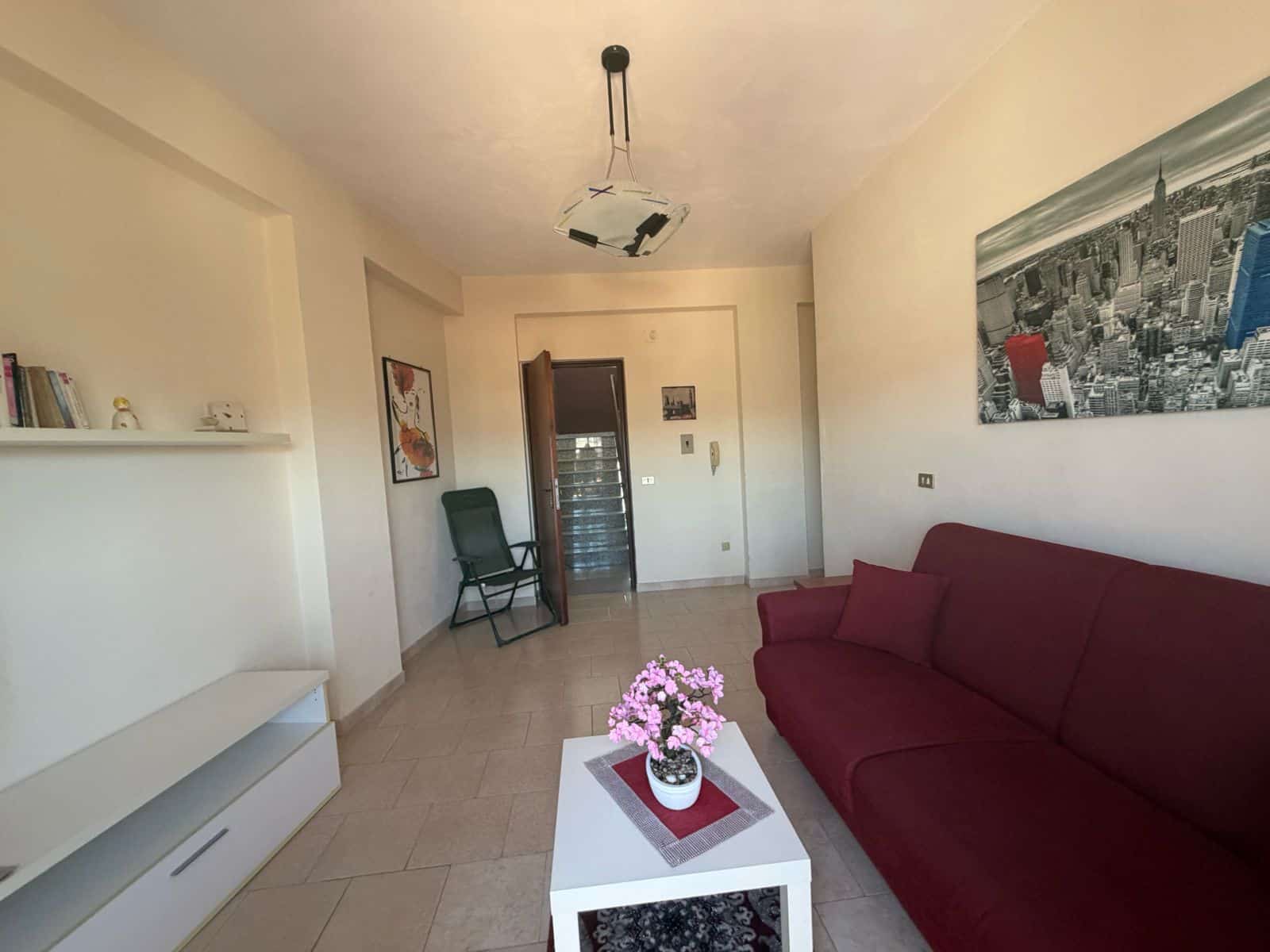 Interno soggiorno di un appartamento in via Comunale Acquitta, Terme Vigliatore, con divano rosso e decorazioni moderne.