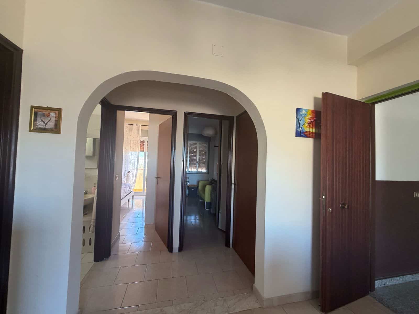 Interno di un appartamento a Terme Vigliatore con porta aperta e arredi moderni.