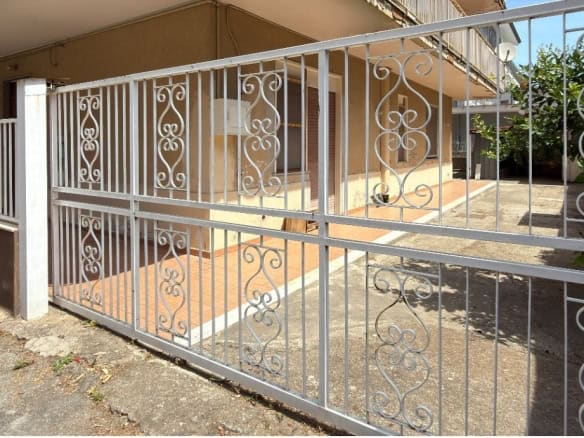Cancello in ferro battuto bianco che delimita l'ingresso di un appartamento semindipendente in Via Medici 443 a Barcellona P.G.