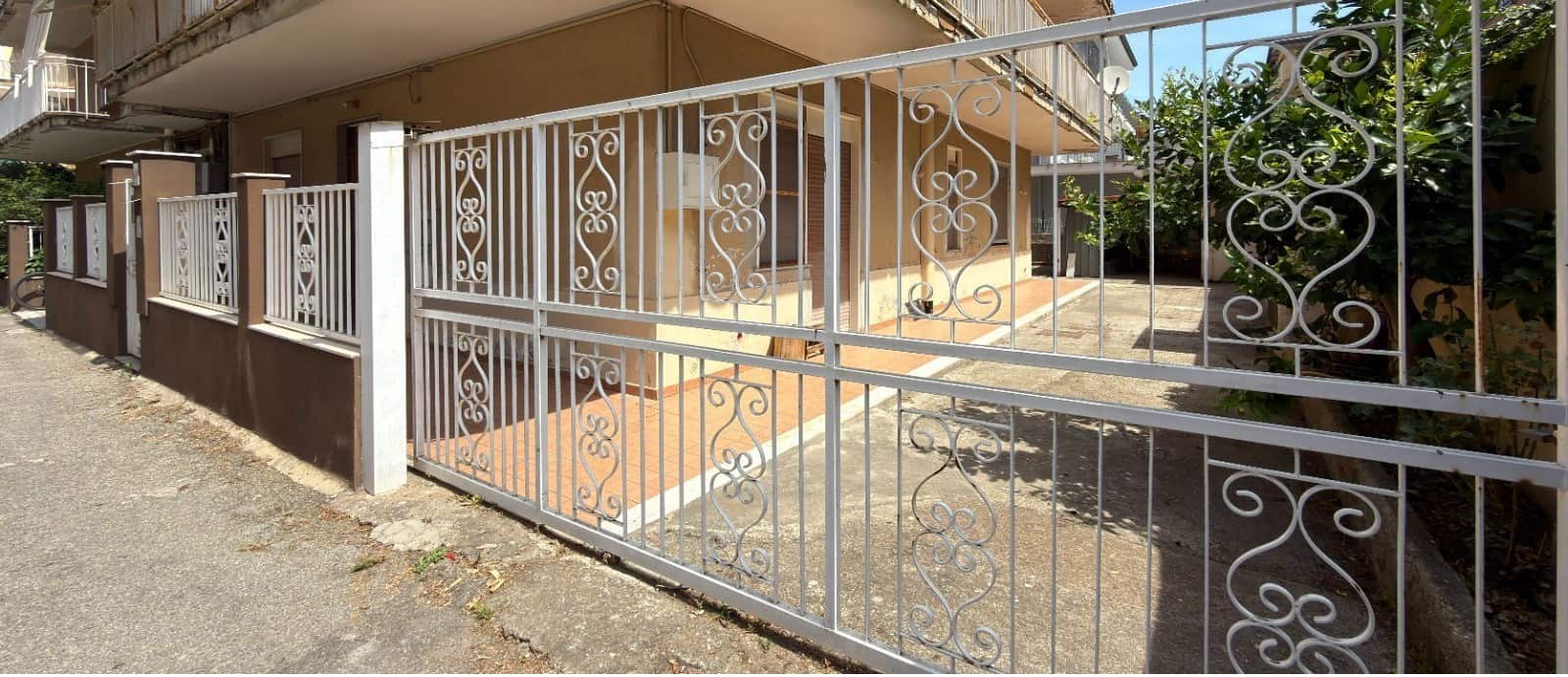 Cancello in ferro battuto bianco che delimita l'ingresso di un appartamento semindipendente in Via Medici 443 a Barcellona P.G.