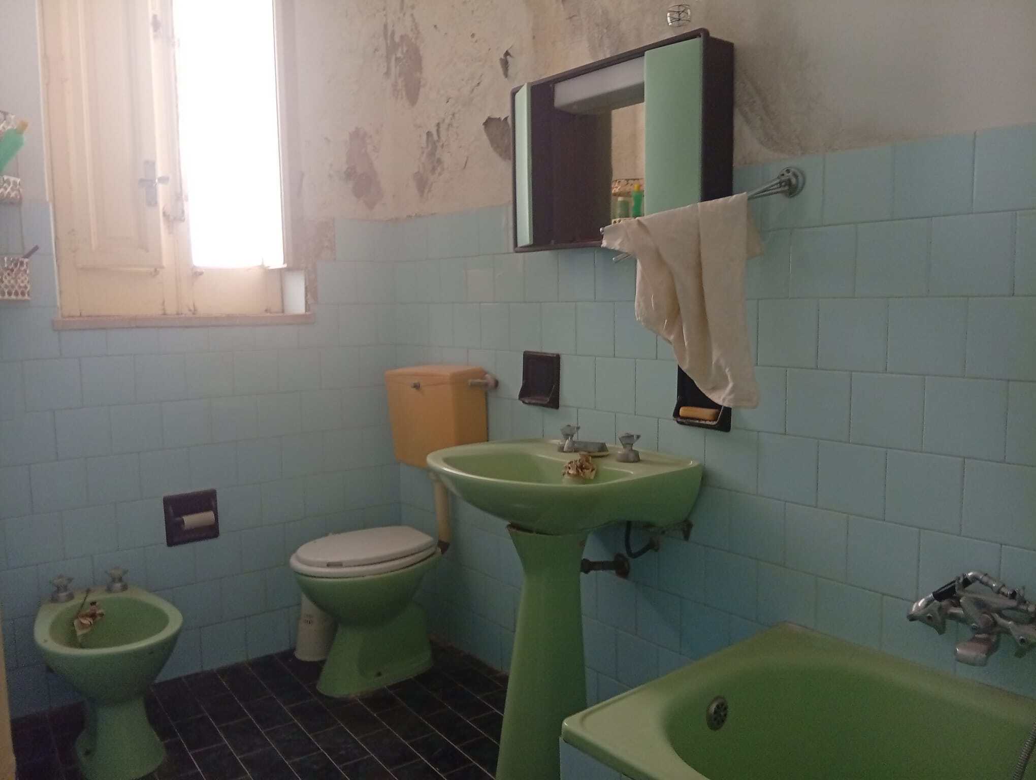 Bagno con lavabo, bidet, wc e vasca in una casa in vendita a Ficarra, Messina.