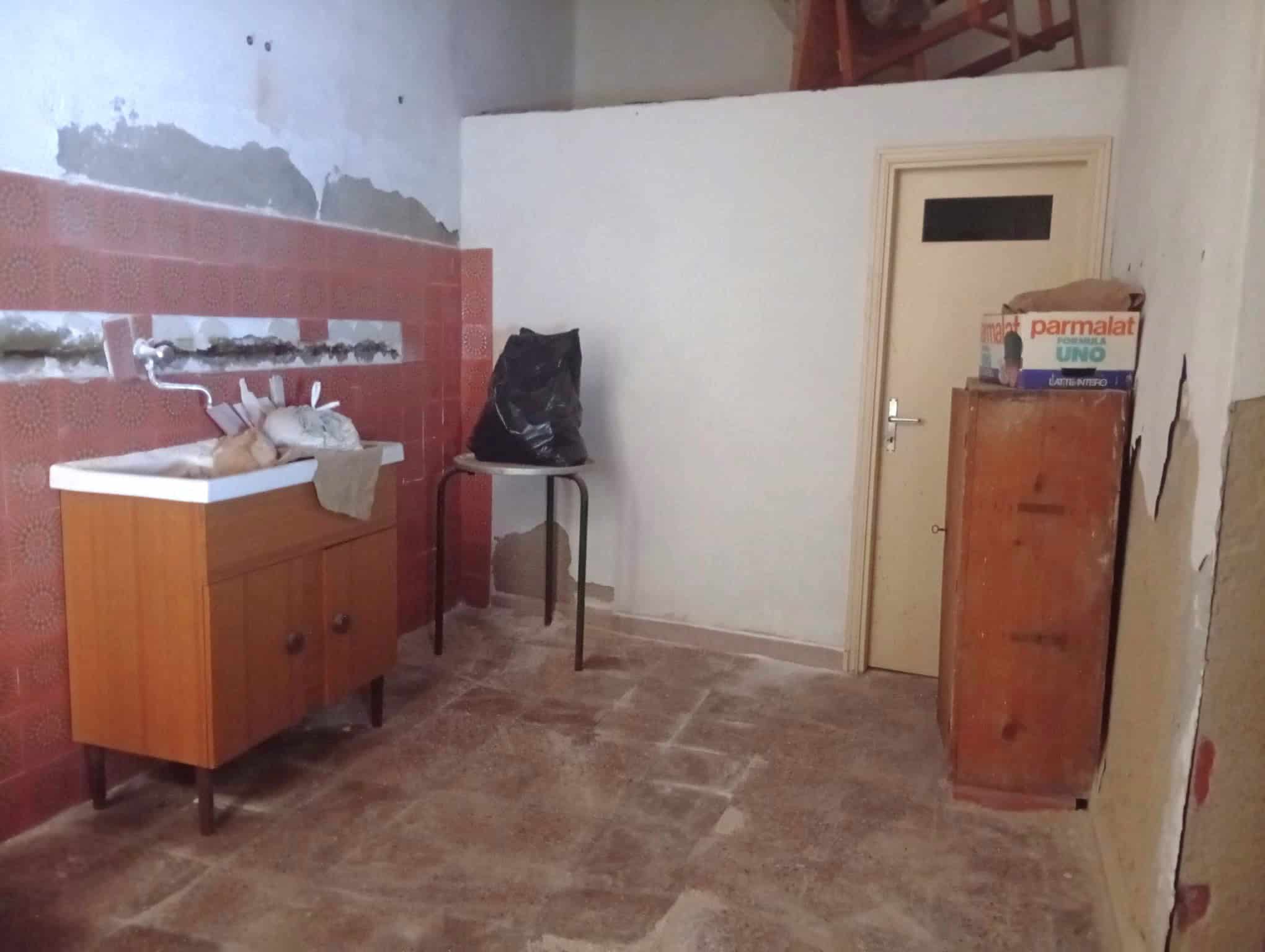 Interno di una casa semidipendente in fase di ristrutturazione con pareti da rifinire e mobili di legno.